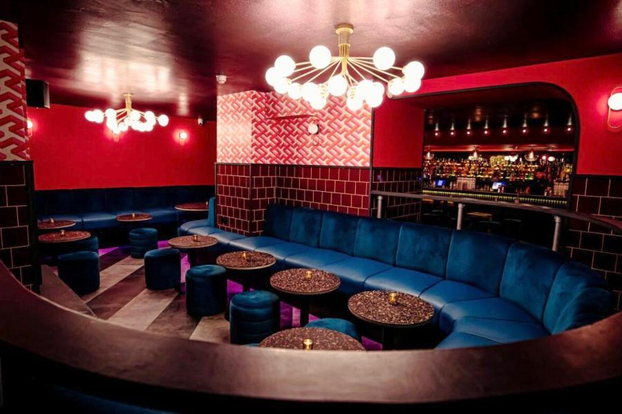 Stylish lounge at The Macbeth with red walls, ideal for networking events and gatherings.