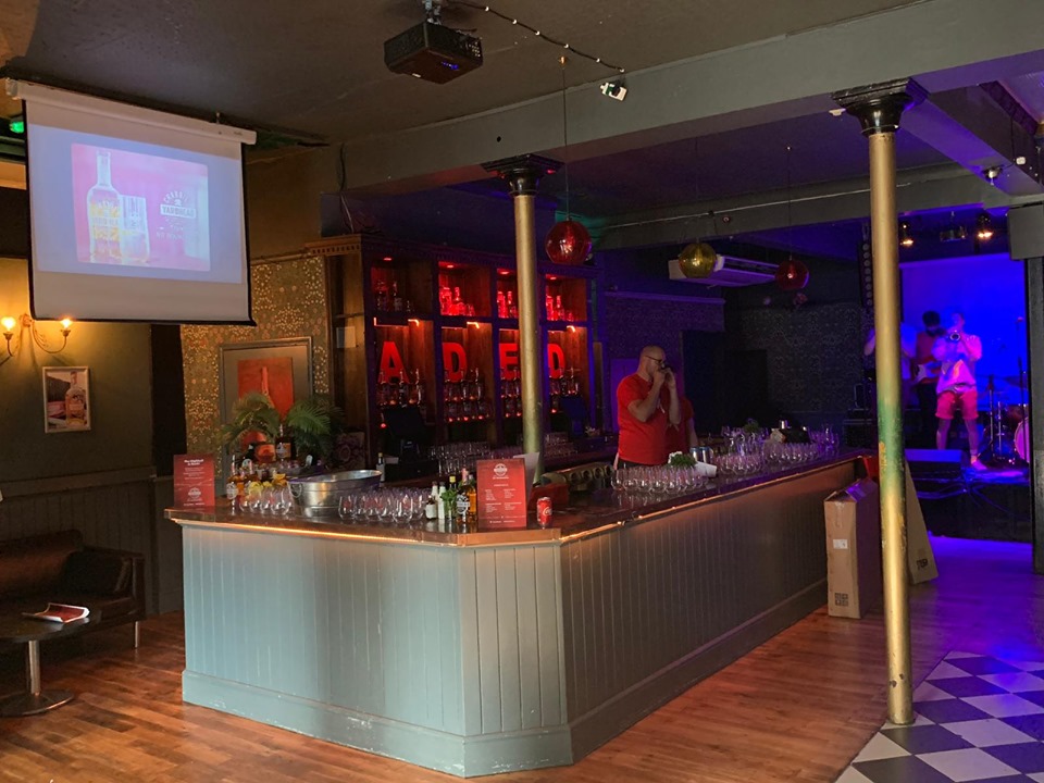 Vibrant event space at The Macbeth with a well-stocked bar for networking events.