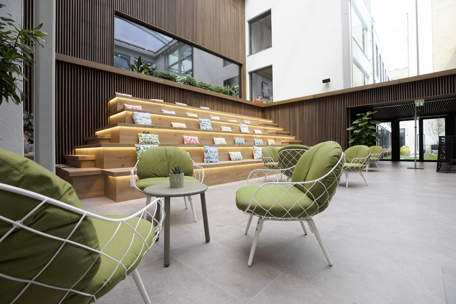 Spitalfields Conservatory event space with stylish green seating and natural light.