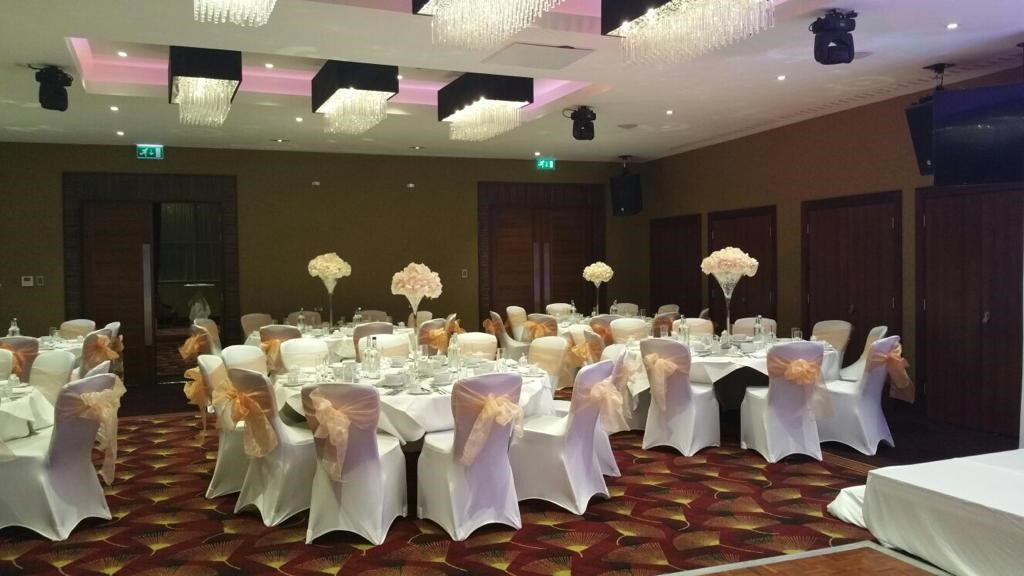 Elegant wedding banquet hall at Holiday Inn Kensington, featuring floral centerpieces and soft lighting.