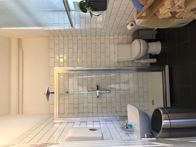 Modern bathroom with glass shower at Marcophysio Westferry for events and meetings.