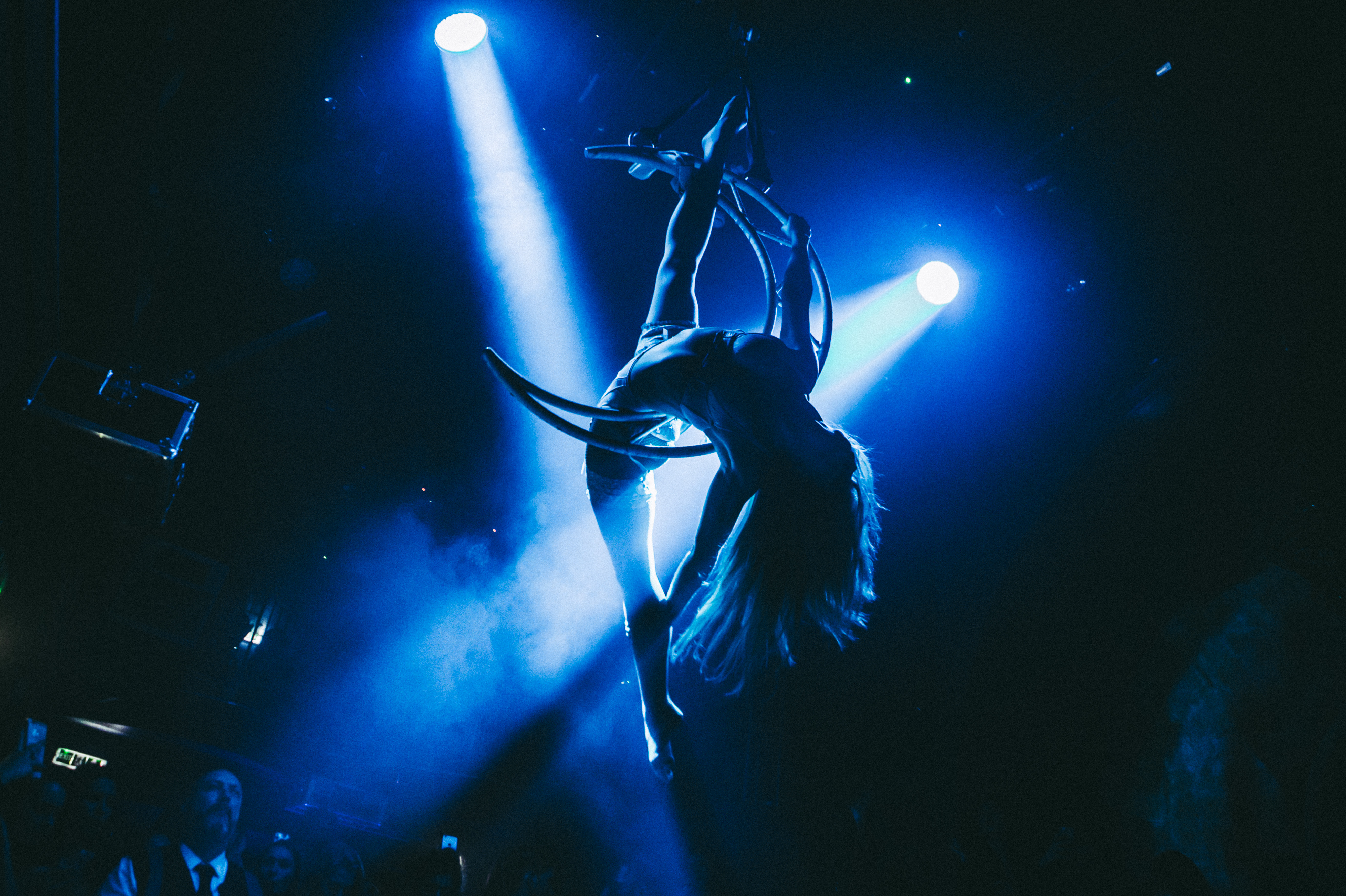 Aerial artist performing under blue lights at The Mezzanine, London Reign event.