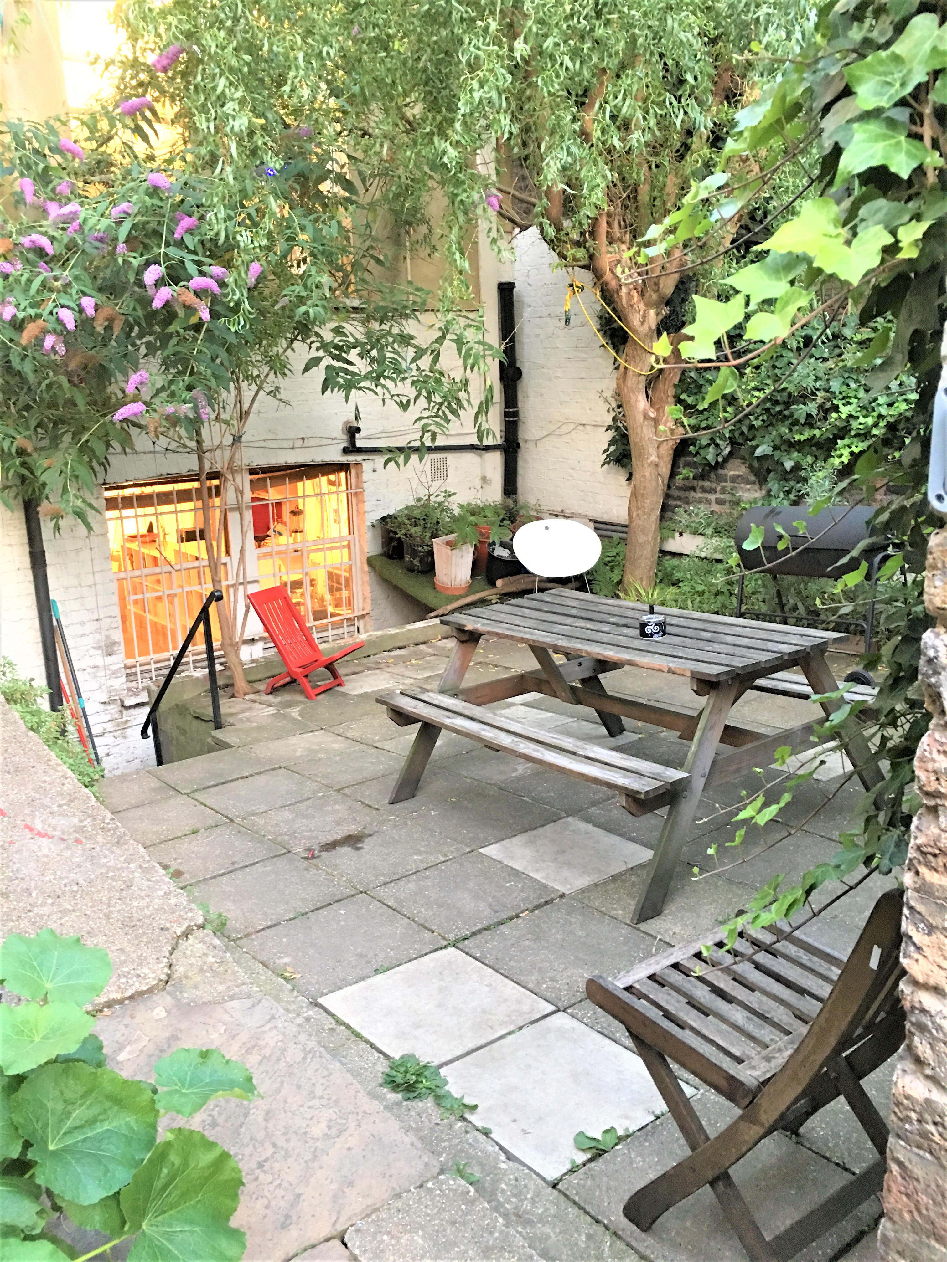 Charming outdoor venue in Dalston Den with rustic picnic table for meetings and events.