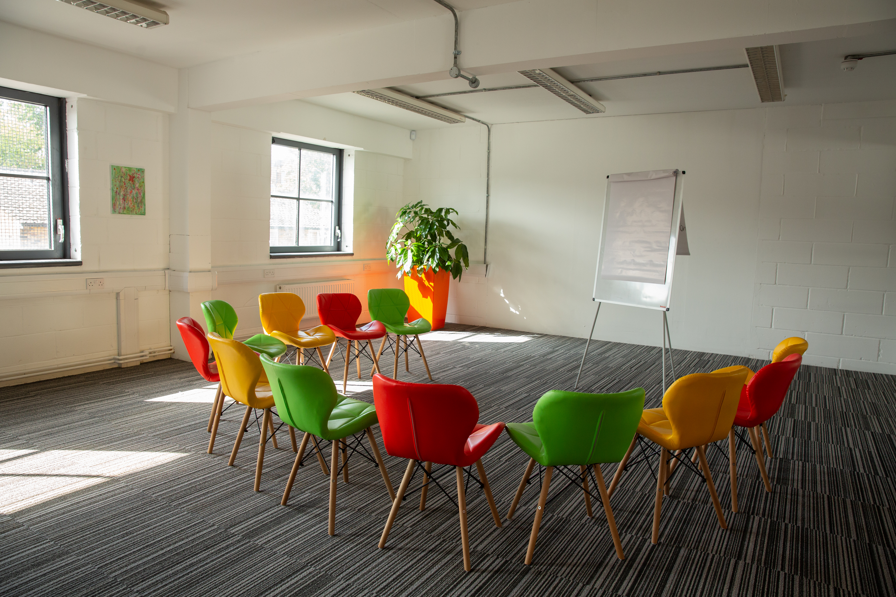 Vibrant meeting space with colorful chairs for workshops and brainstorming sessions.