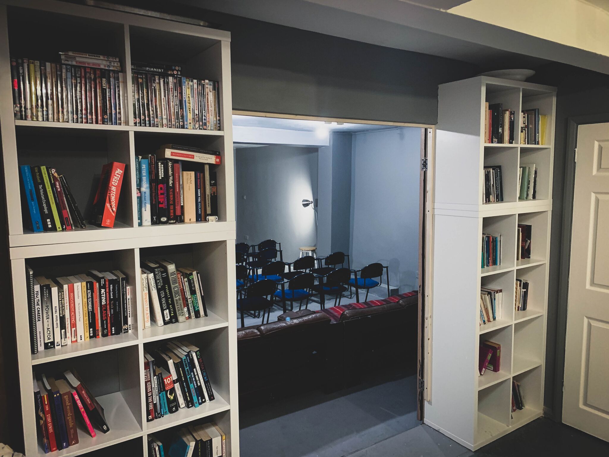 Cozy AE Studio venue with bookshelves, ideal for workshops and small conferences.