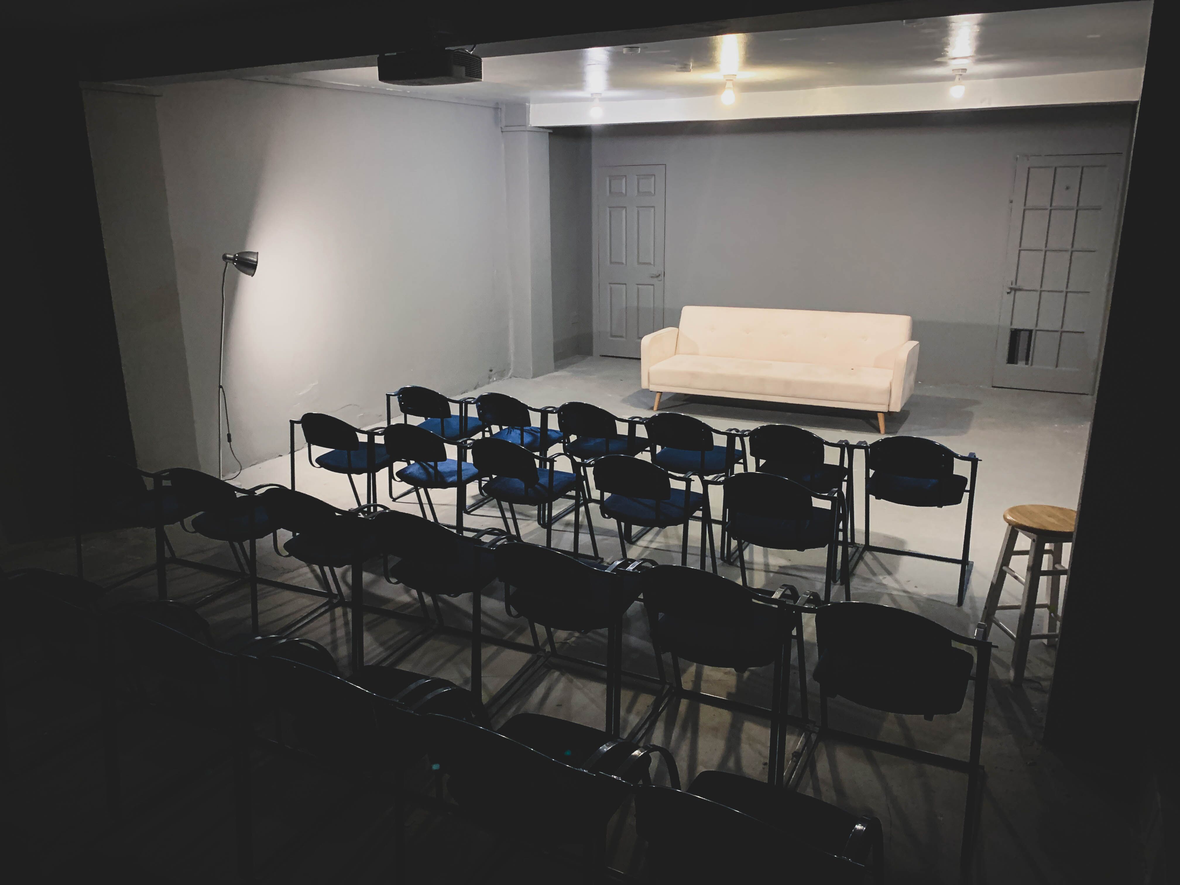 Minimalist event space in AE Studio for presentations and workshops with black chairs.