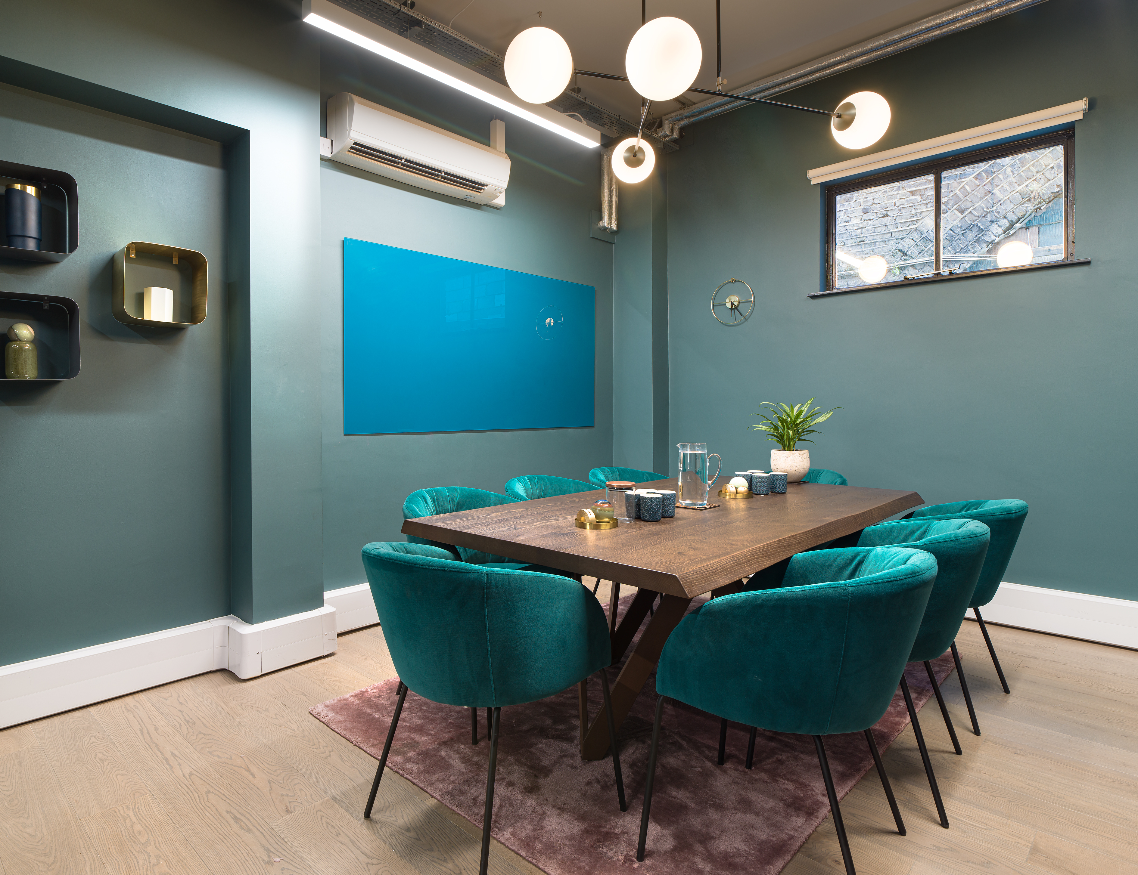 Stylish meeting room with teal walls and plush chairs for creative brainstorming sessions.