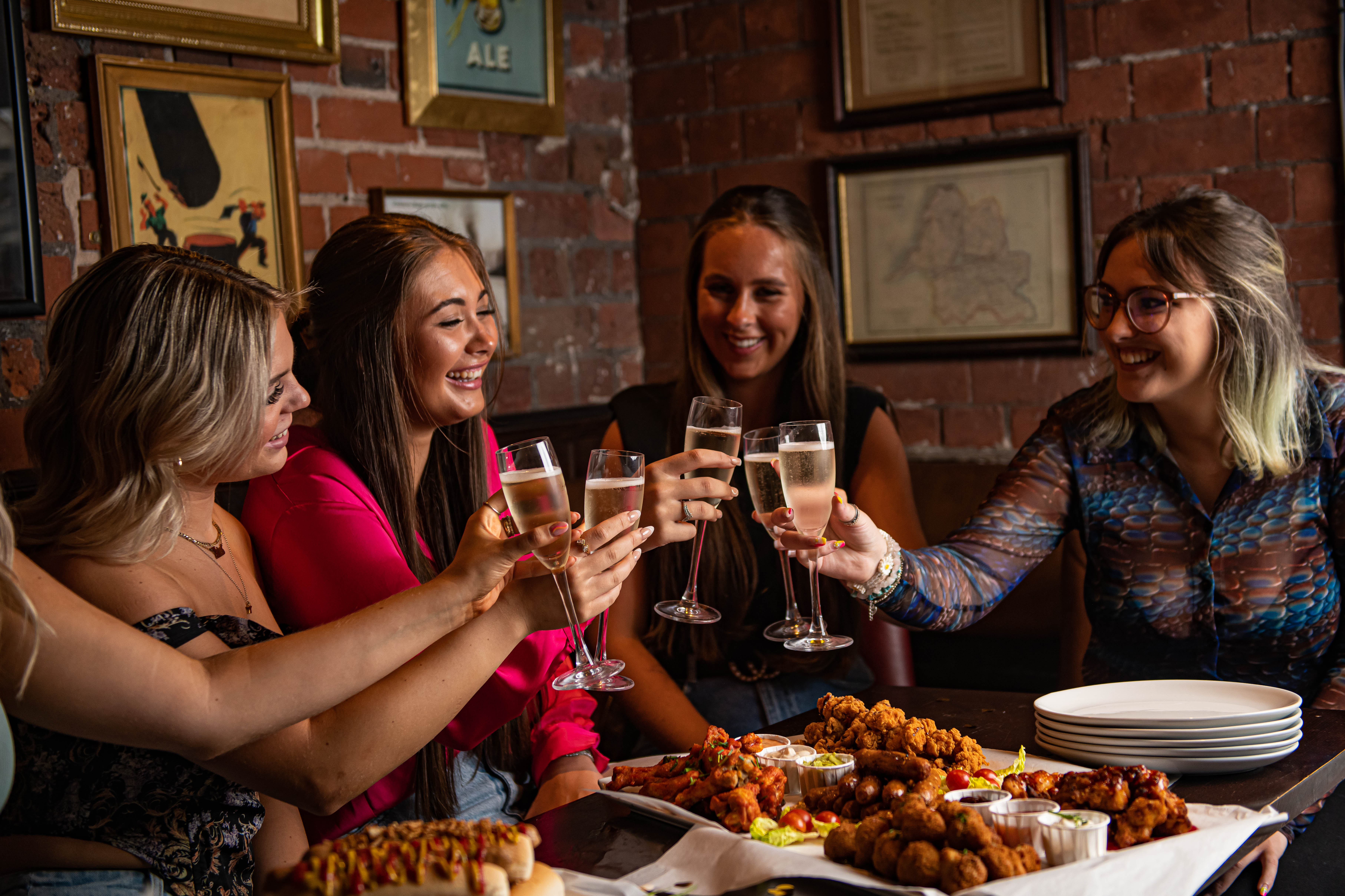 Friends toasting in a warm, festive atmosphere at Snug, Punch Tarmey's Liverpool.
