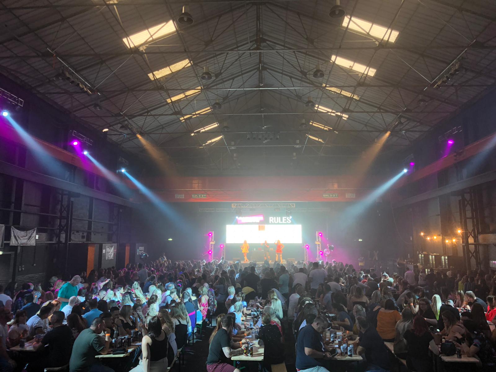 Vibrant event space in The Hangar with dynamic lighting for networking and entertainment.