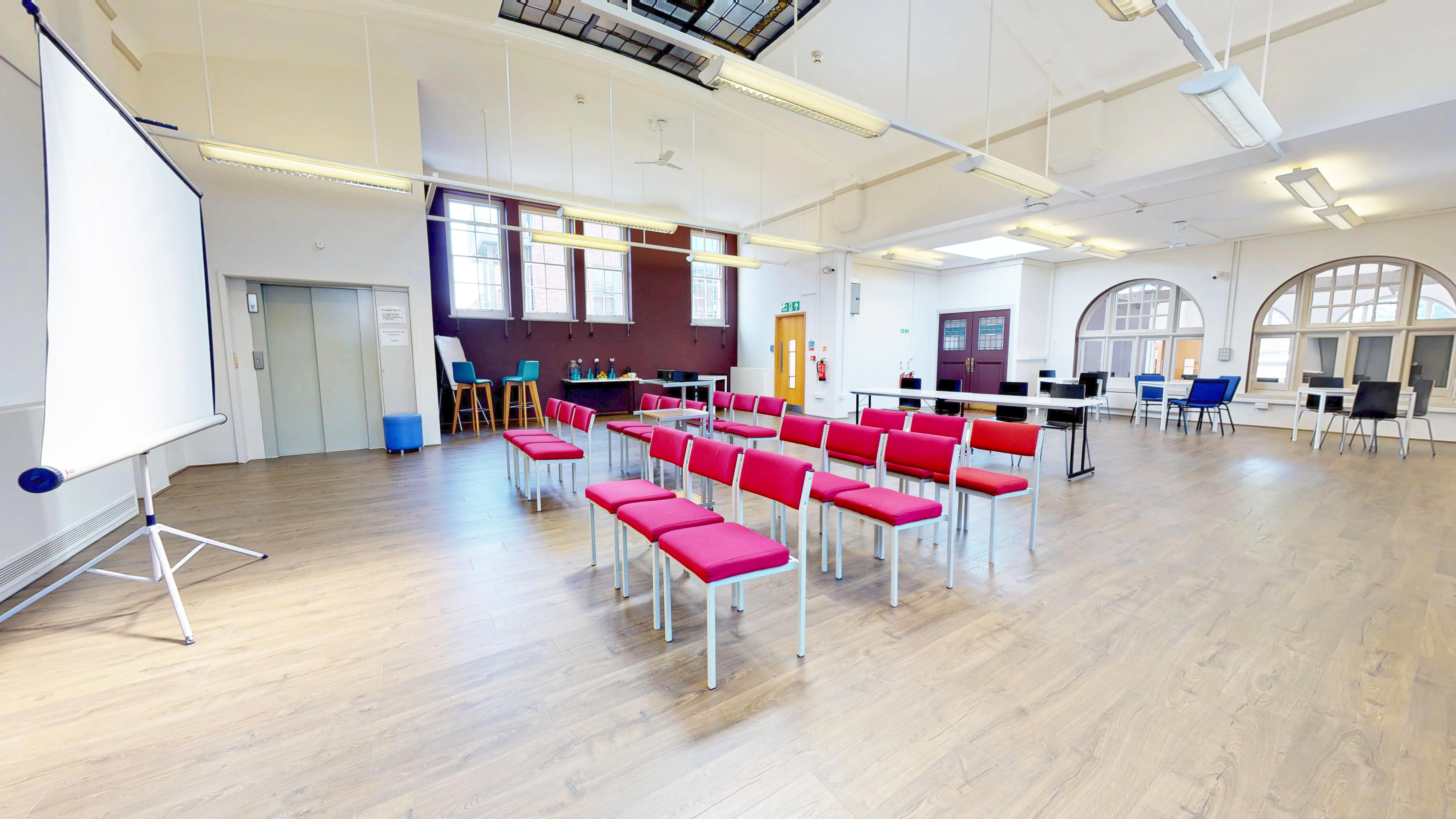 Burgundy Room event space with red chairs, perfect for workshops and meetings.