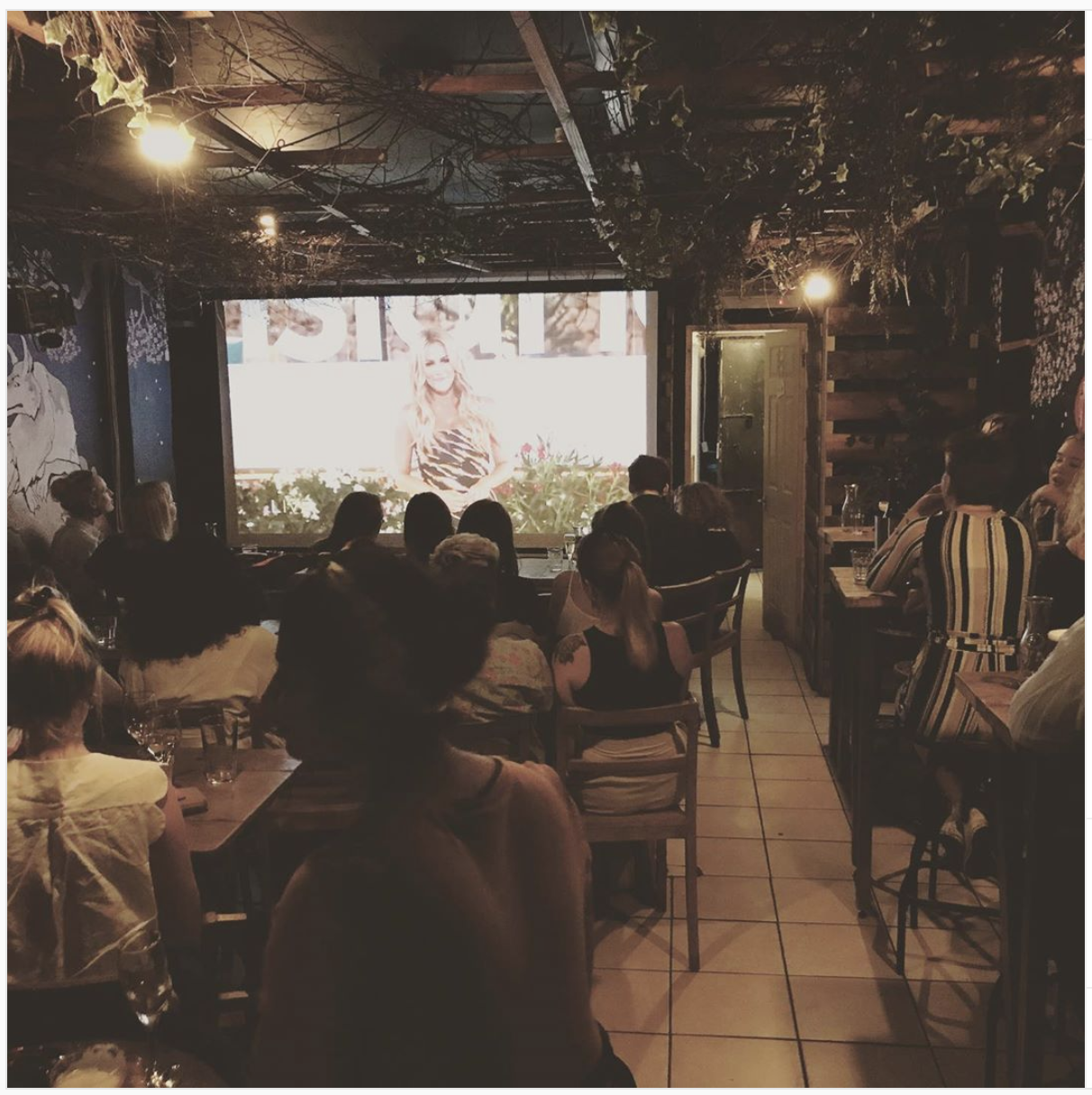 Cozy Secret Garden Room set for a screening event with ambient lighting and seating.