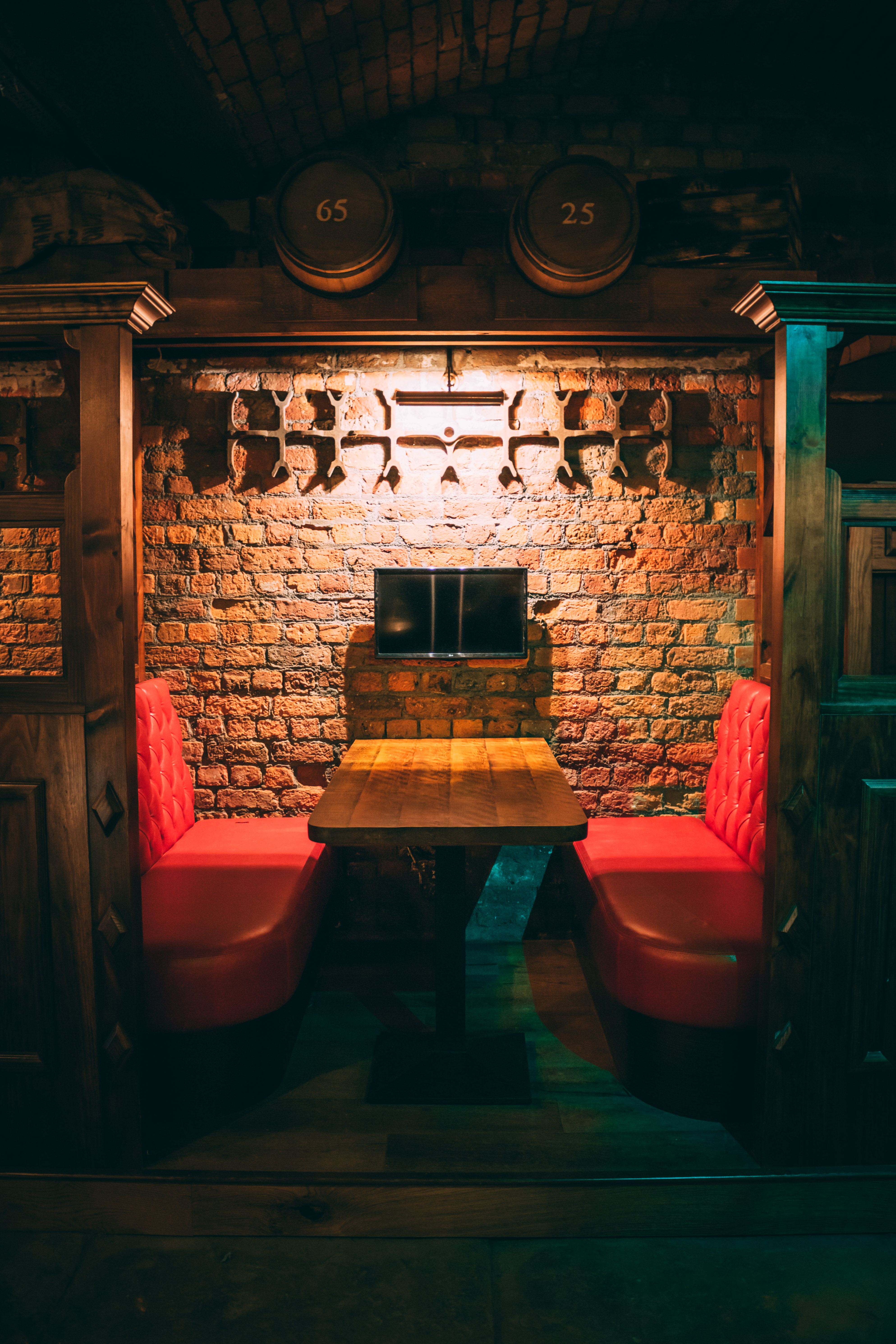 Cozy Brewery Hall meeting space with rustic brick wall and red booths in Liverpool.