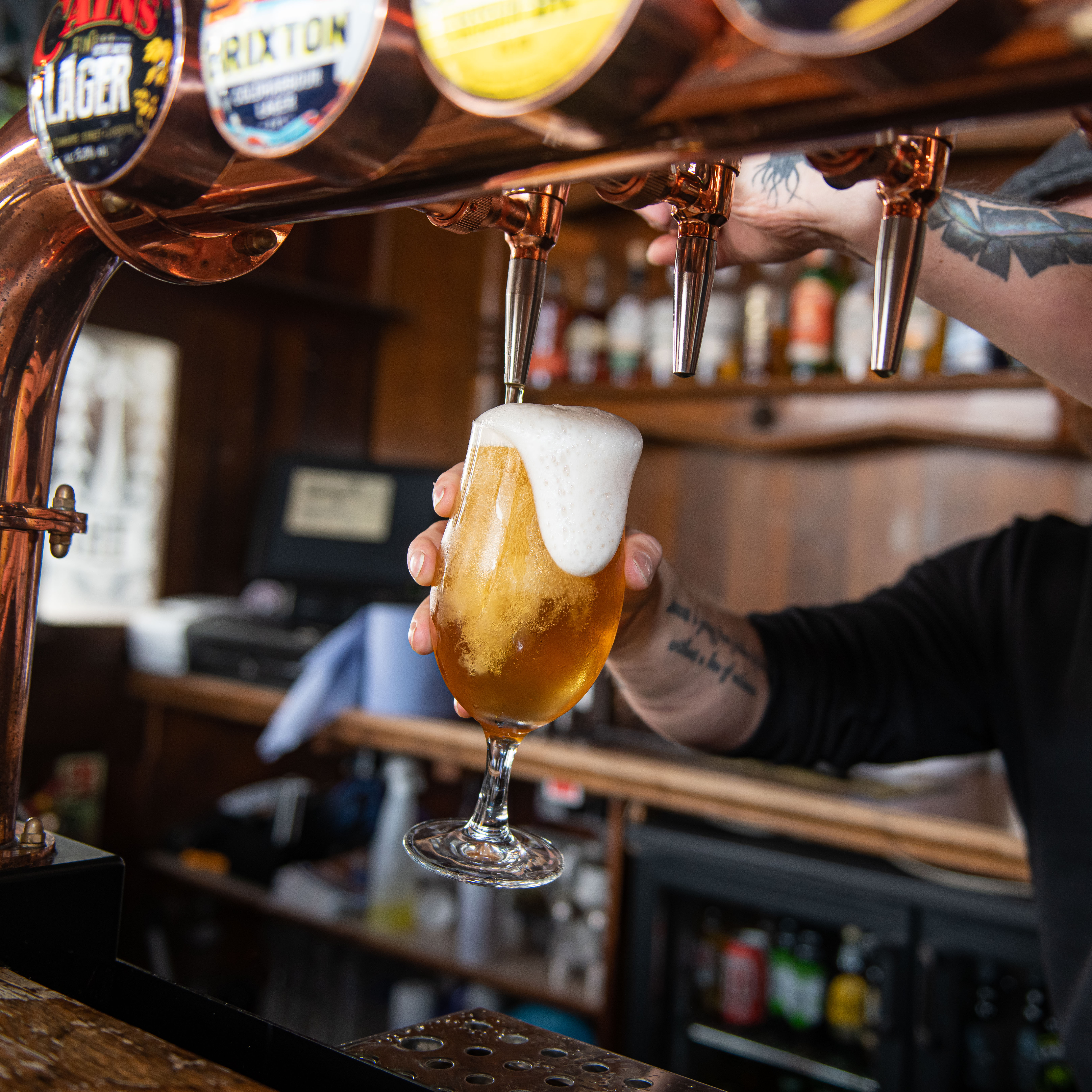 Bartender pouring draft beer at The Brewery Tap, enhancing event beverage service.