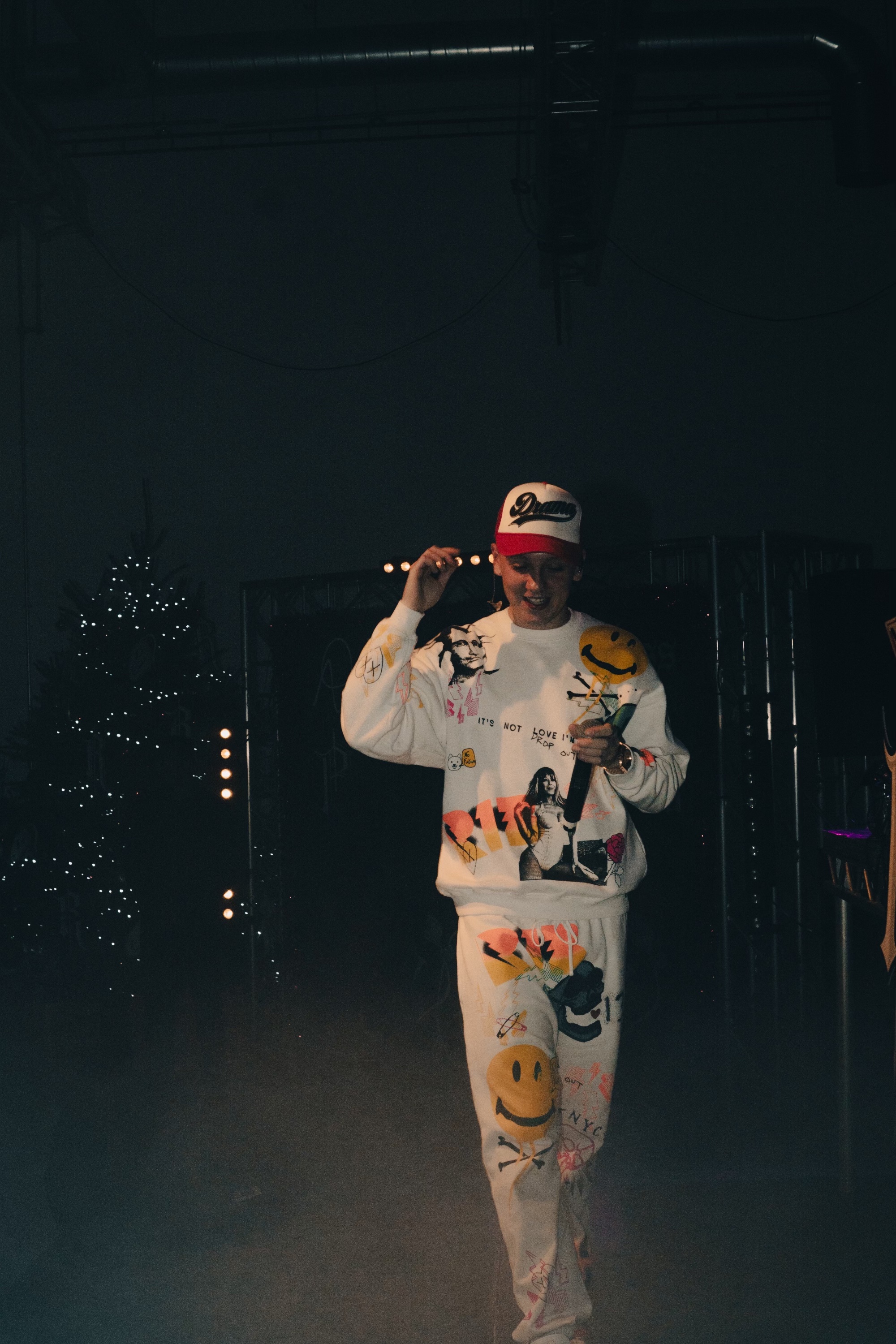 Energetic performer in vibrant attire on stage at a lively event in Studio One.