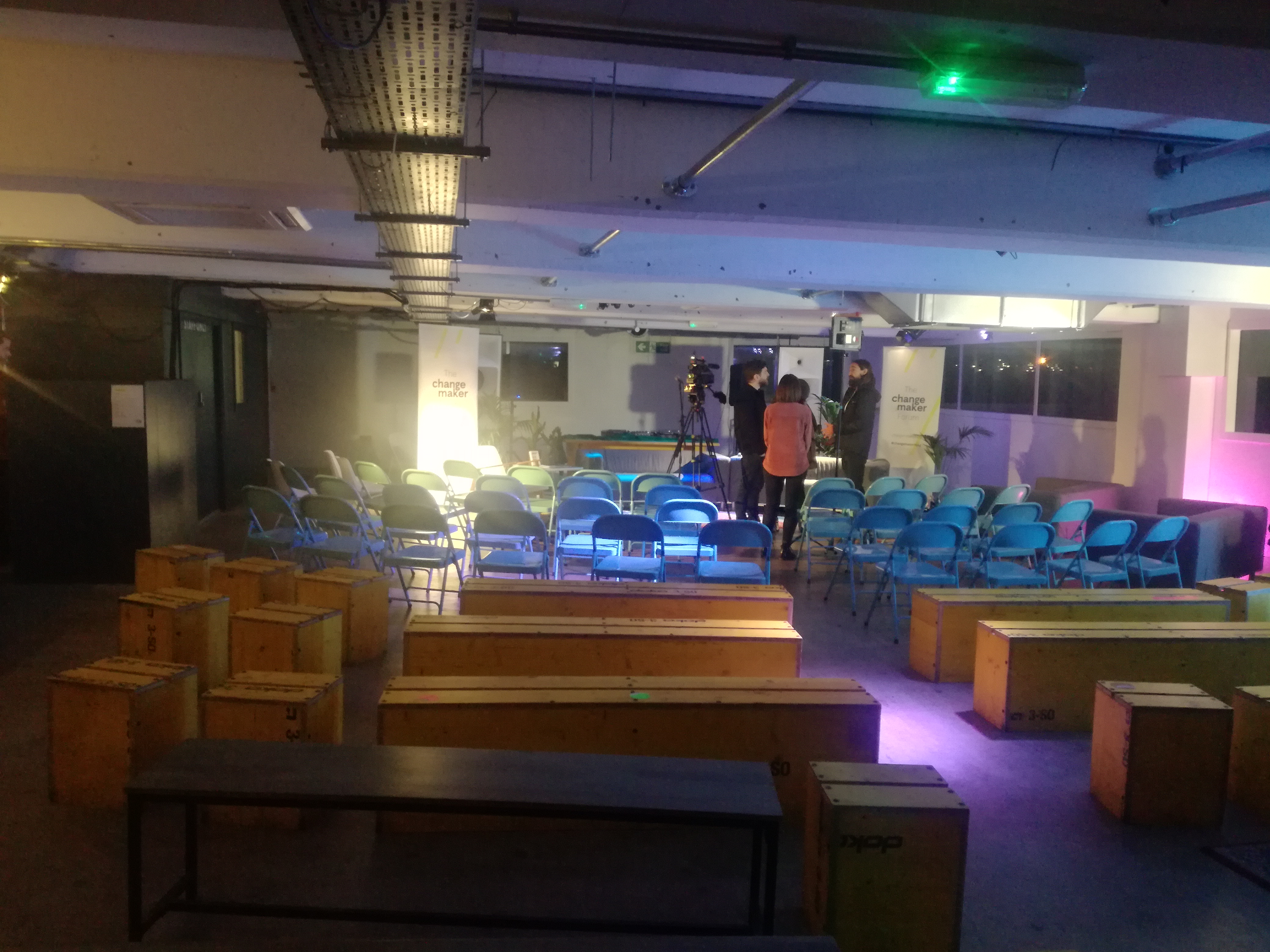 Versatile event space in Peckham Gallery with blue chairs for gatherings and presentations.