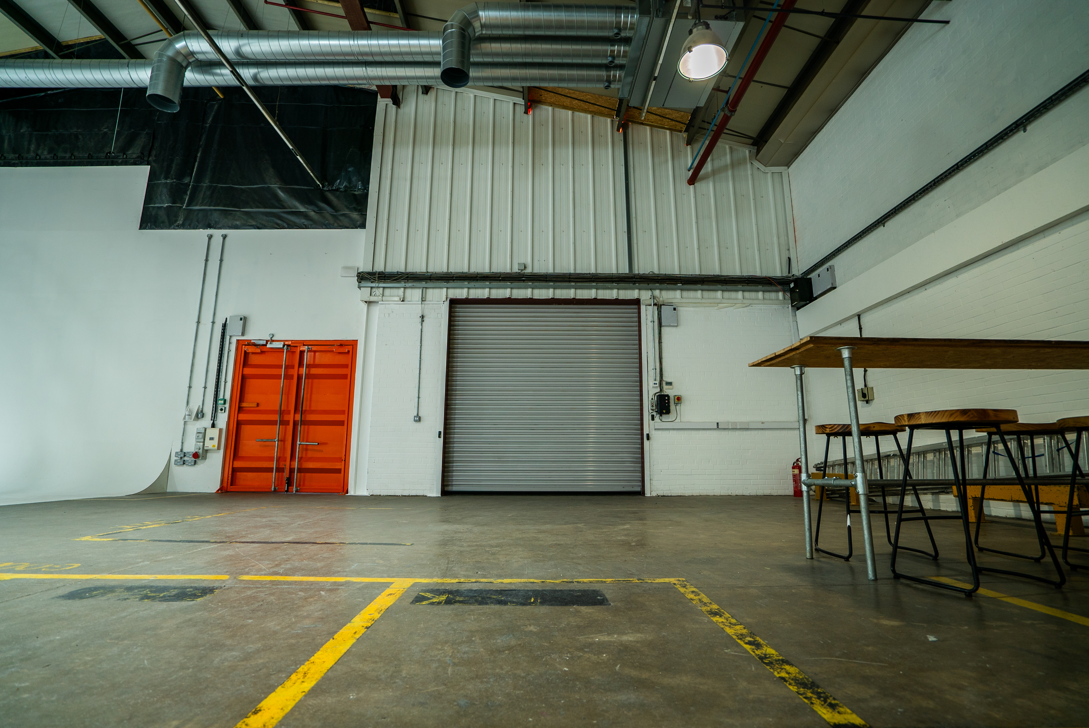Versatile industrial event space with roll-up door for creative workshops and meetings.