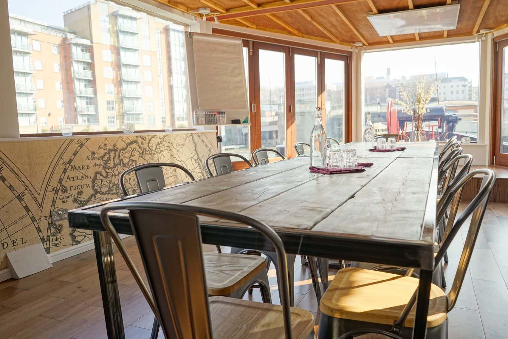 Well-lit meeting space with wooden table, ideal for collaborative discussions and events.