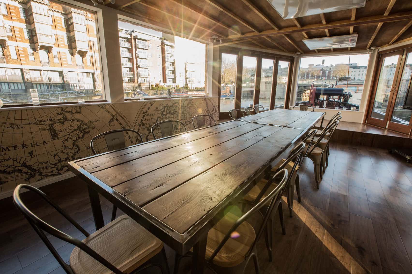 Spacious meeting room with wooden table and natural light at THE BRIDGE, Floating Harbour.