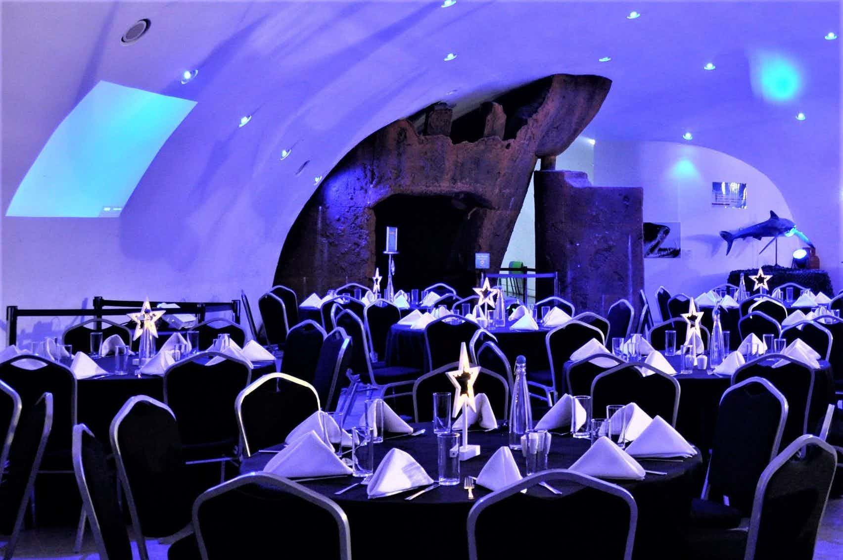 Elegant event space with round tables at Bristol Aquarium for upscale dinners and corporate events.