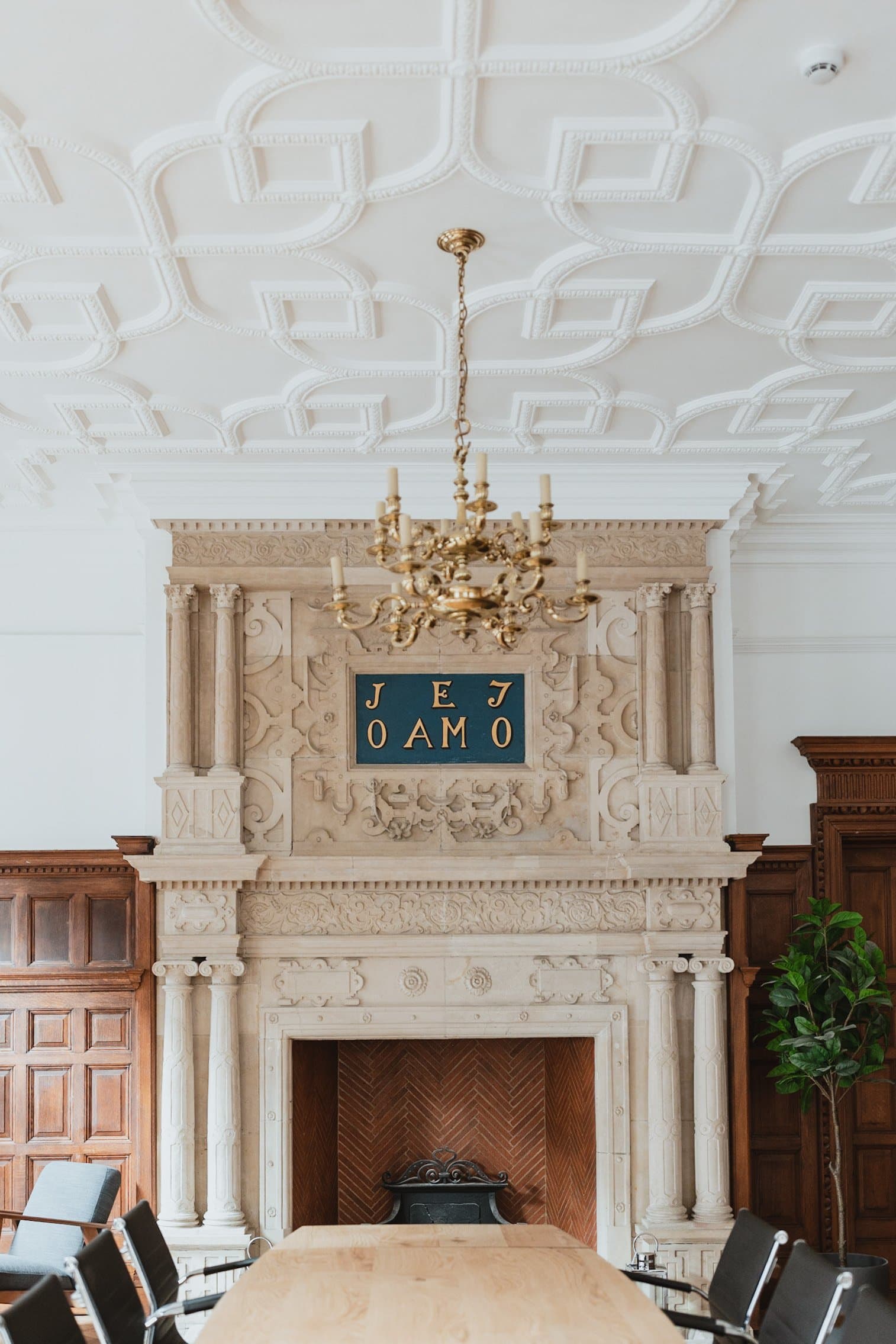 Elegant event space at The Brunel with grand fireplace and chandelier for upscale gatherings.