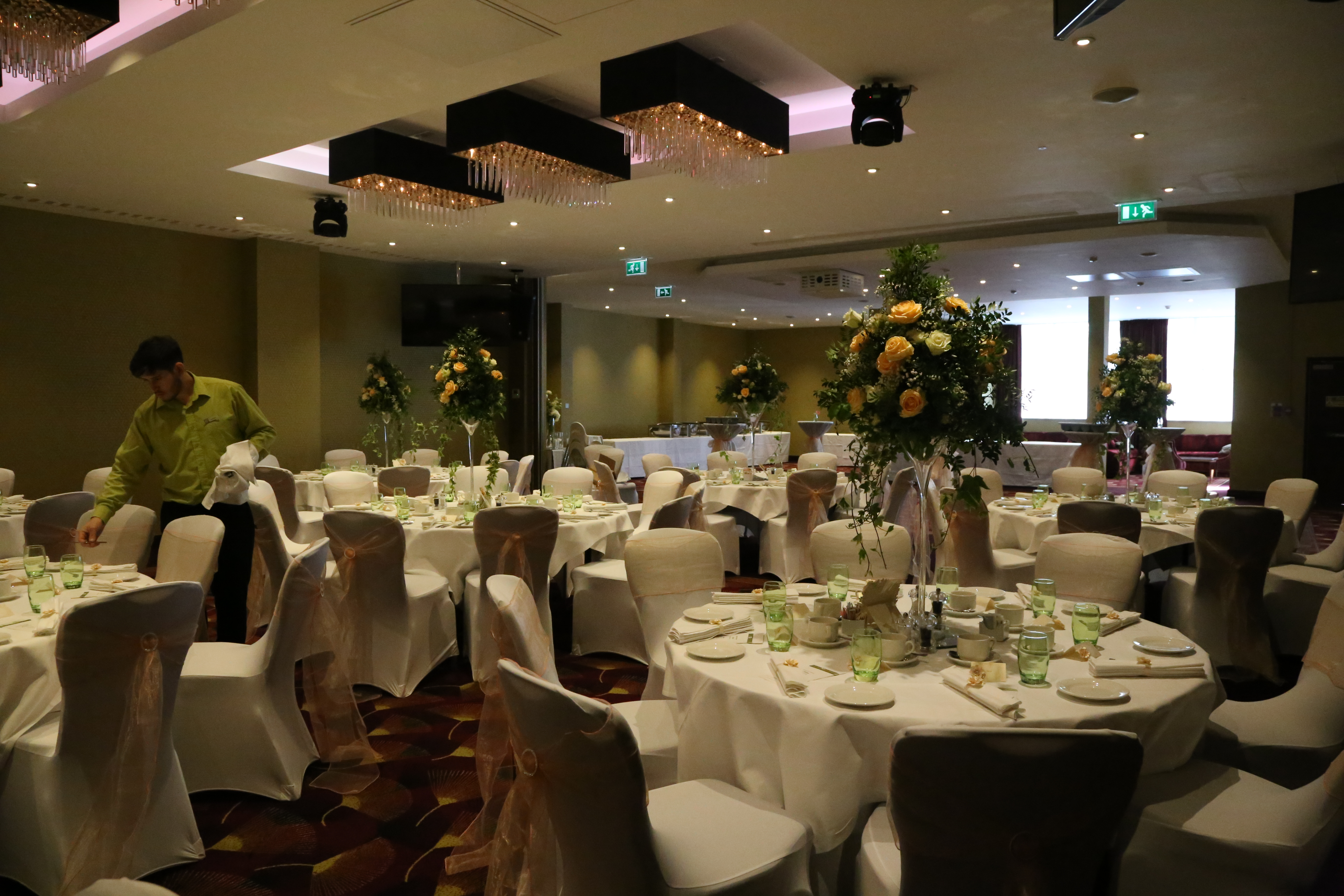 Elegant wedding banquet hall at Holiday Inn Kensington, featuring floral centerpieces.