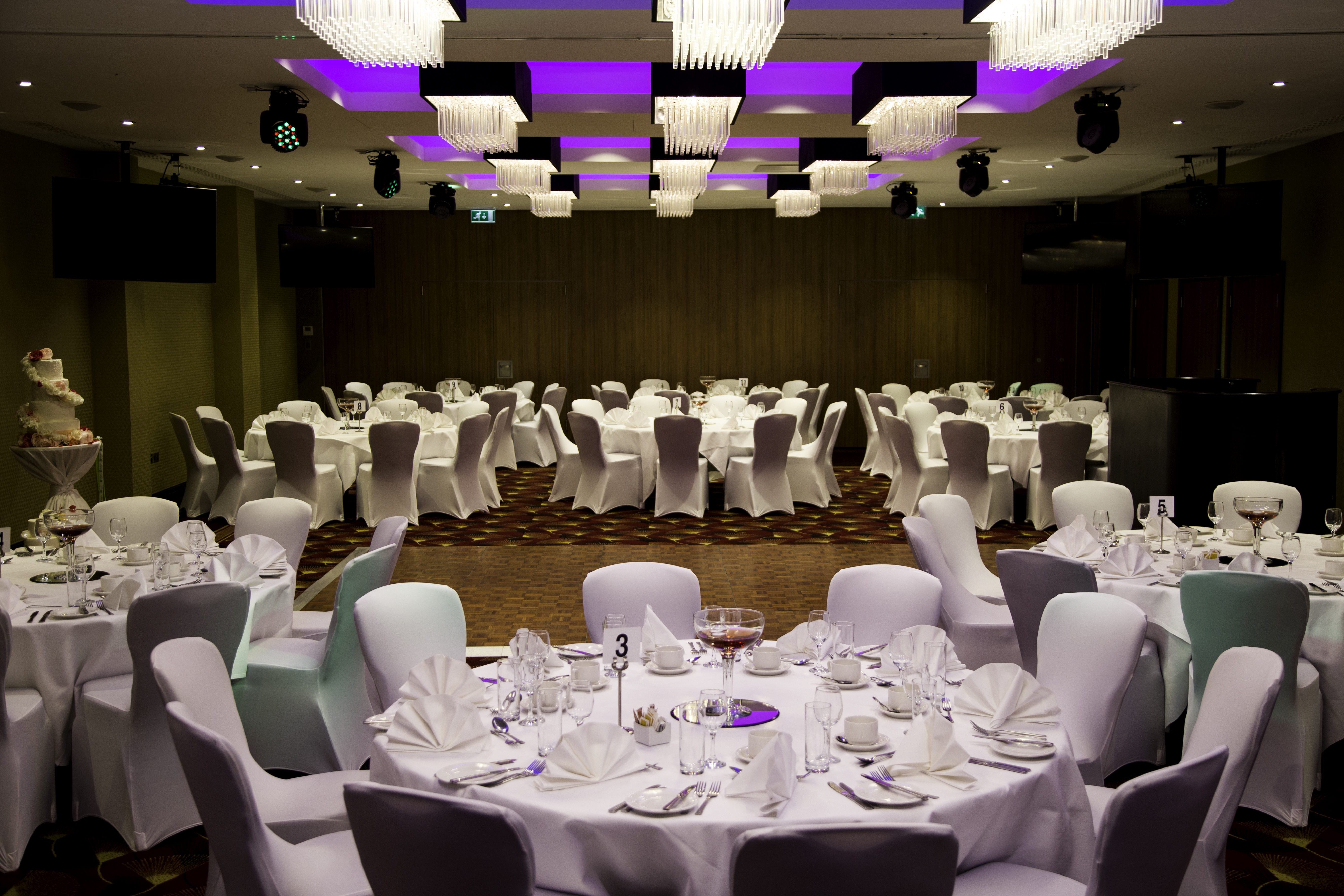 Elegant wedding banquet room at Holiday Inn Kensington, featuring stylish round tables.