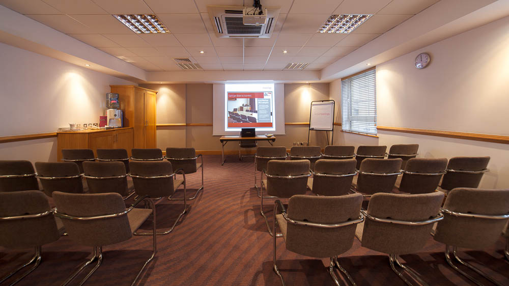 Meeting room at Jury's Inn Glasgow with comfortable chairs for presentations and discussions.