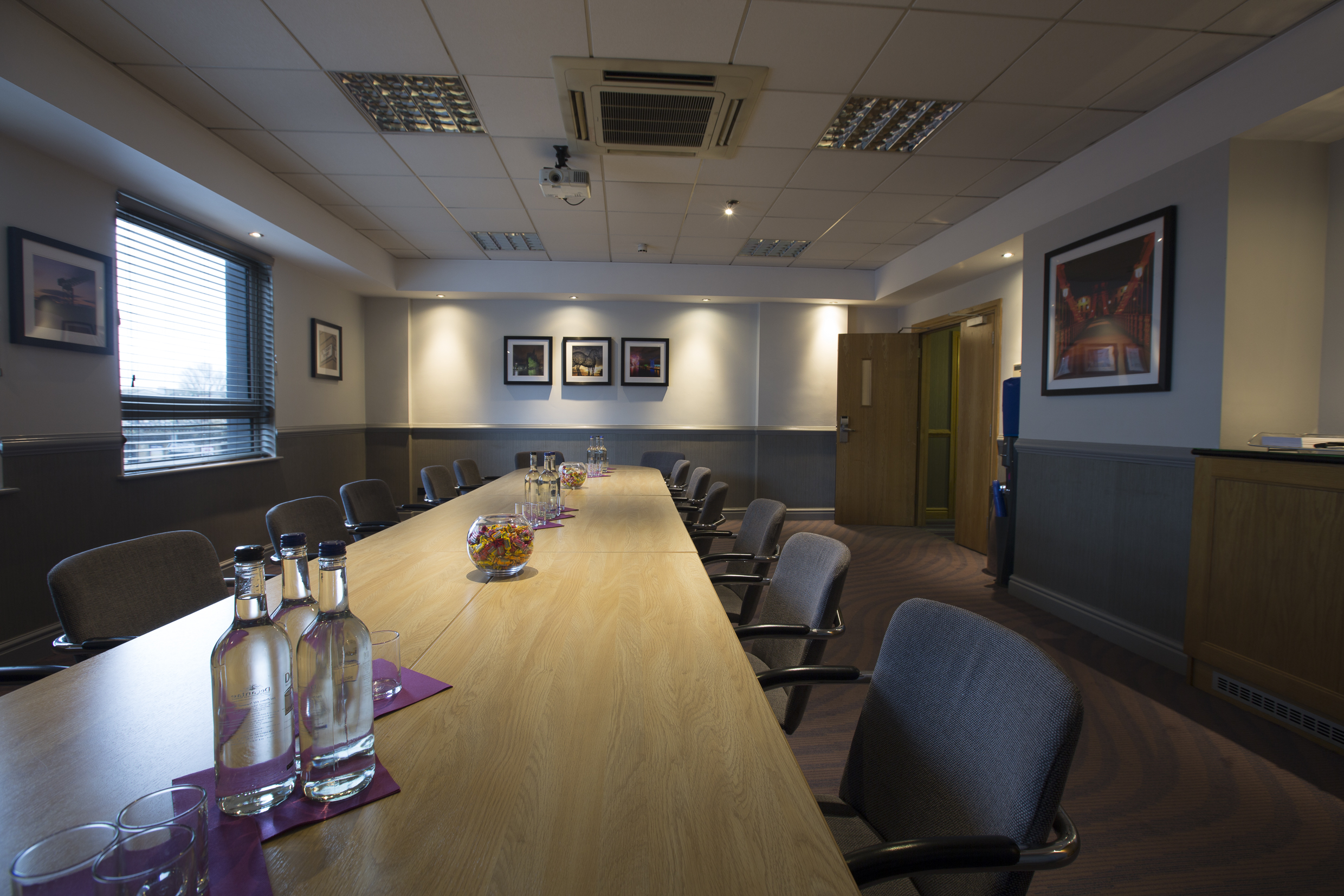 Meeting room in Jury's Inn Glasgow with long table, ideal for presentations and discussions.