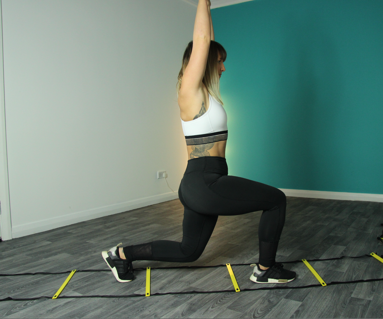 Gym yoga studio with participant lunging in vibrant fitness event setup.