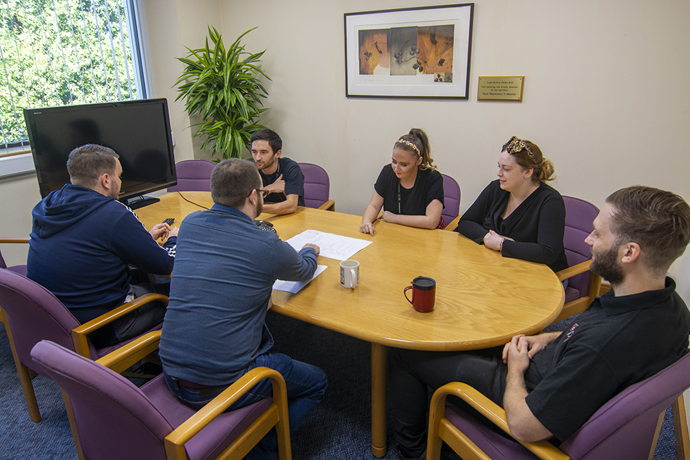"Bonner Suite meeting with six professionals collaborating around a round table."