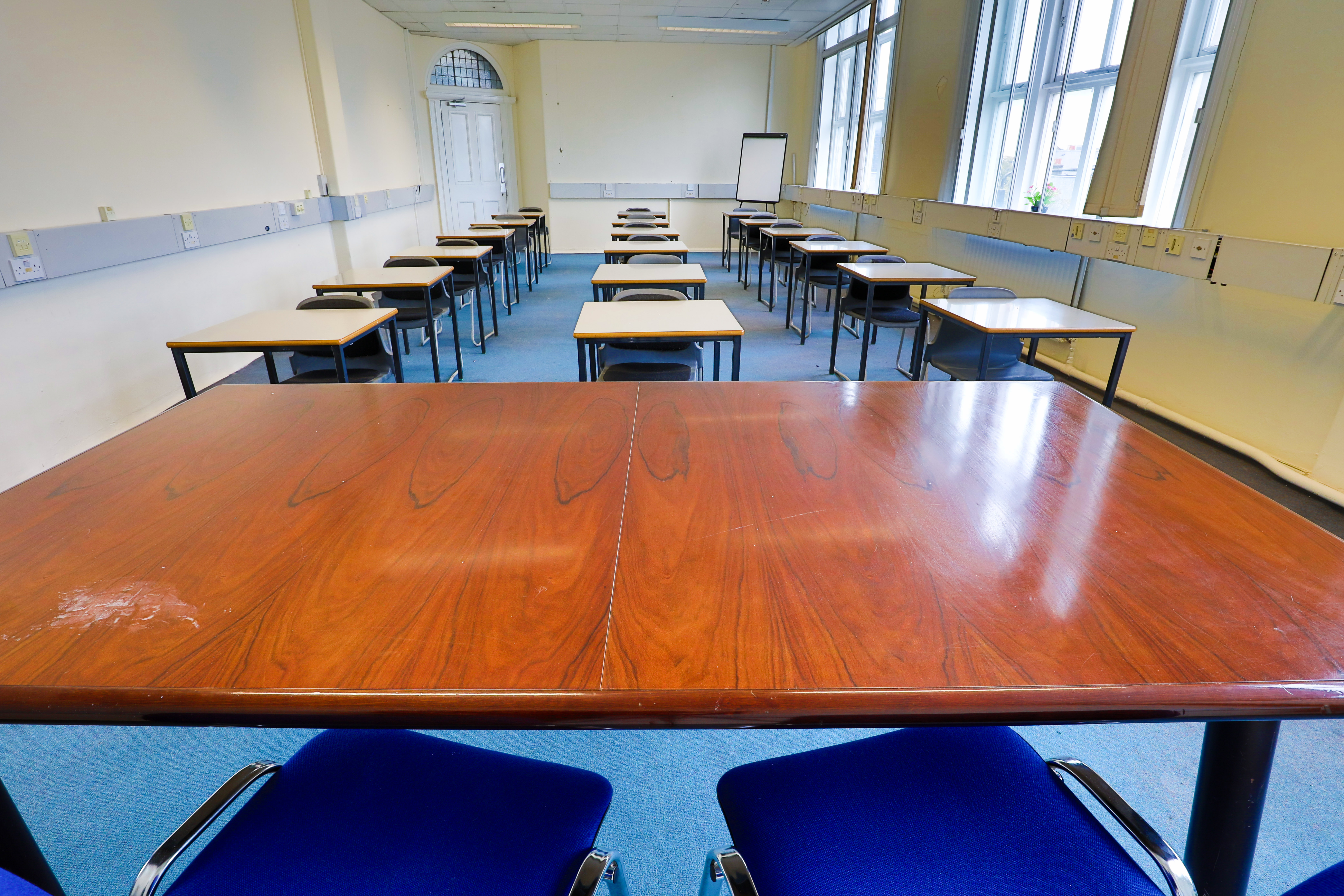 Spacious conference room with natural light, ideal for workshops and training sessions.