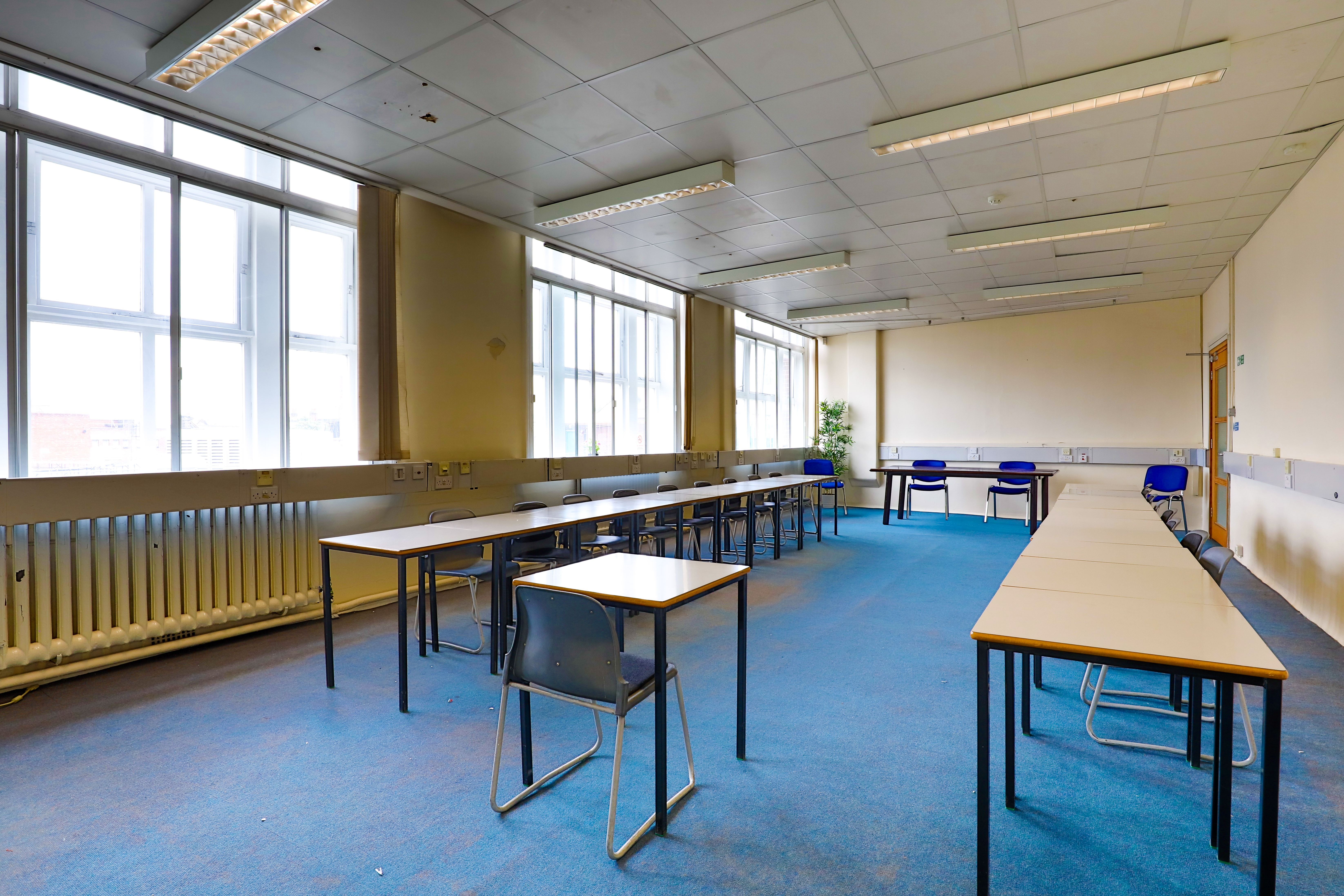 Spacious conference room with natural light, ideal for workshops and training sessions.