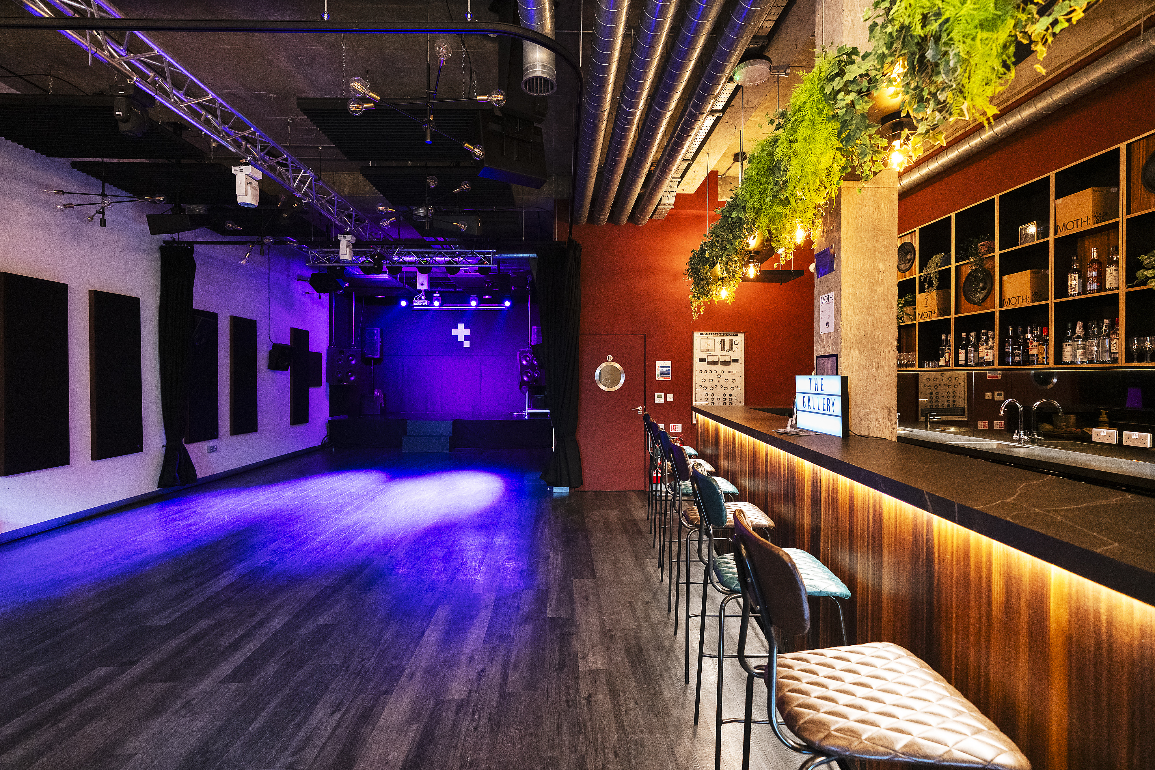 Versatile event space in Tileyard London with sleek bar and open stage for gatherings.