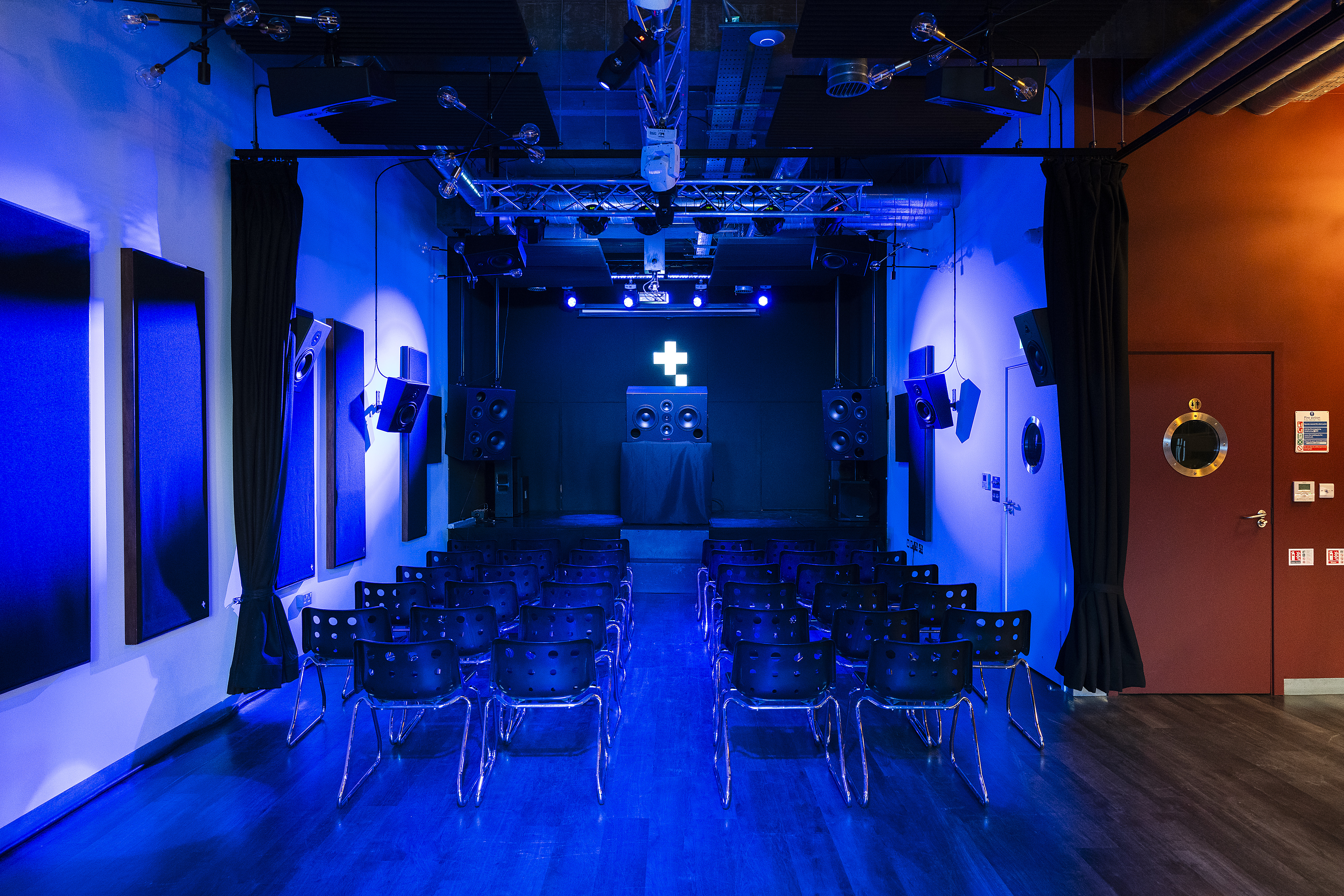 Versatile event space in Tileyard London with sleek stage and professional lighting.