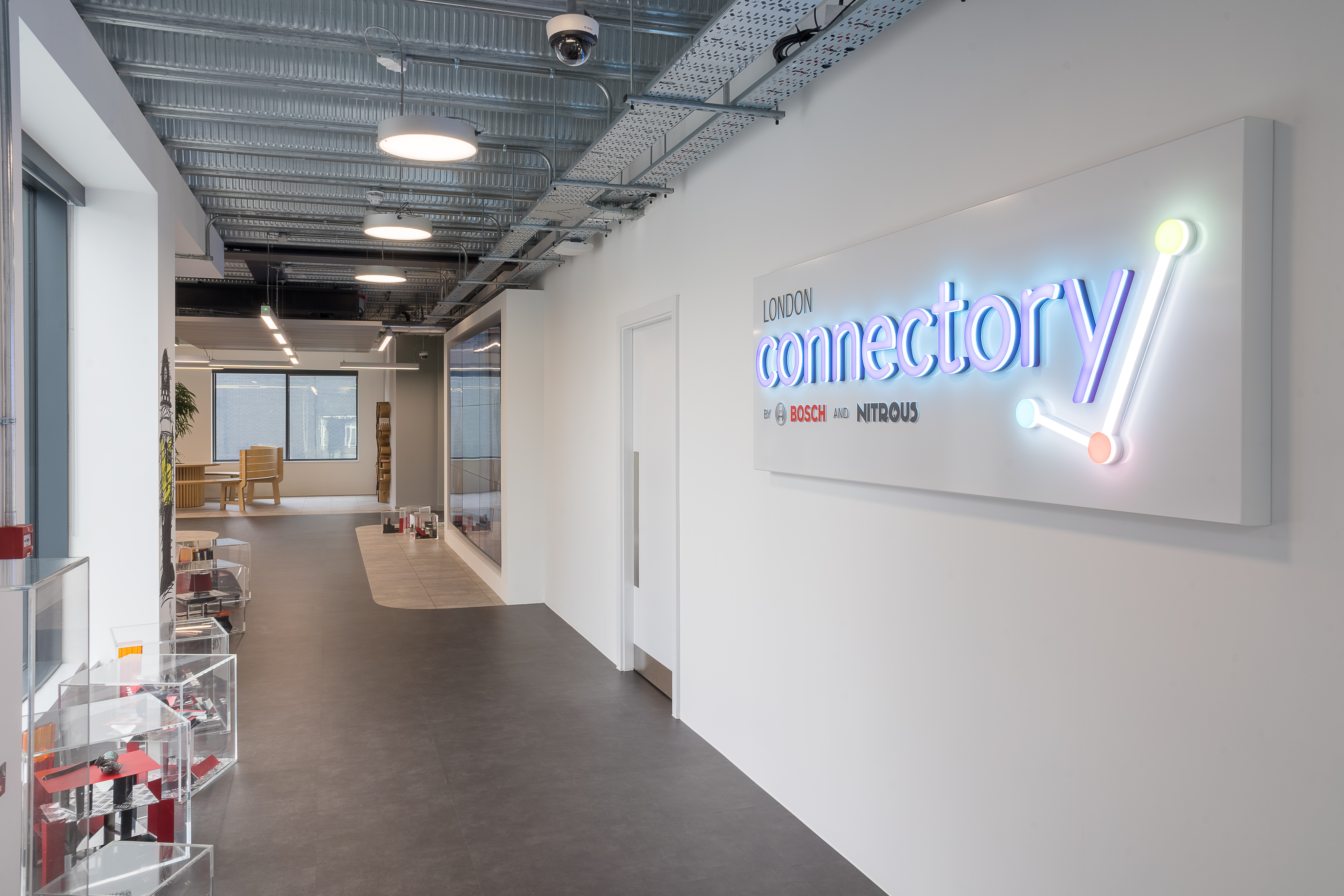 Modern London corridor with neon "connectory" sign, perfect for workshops and networking.