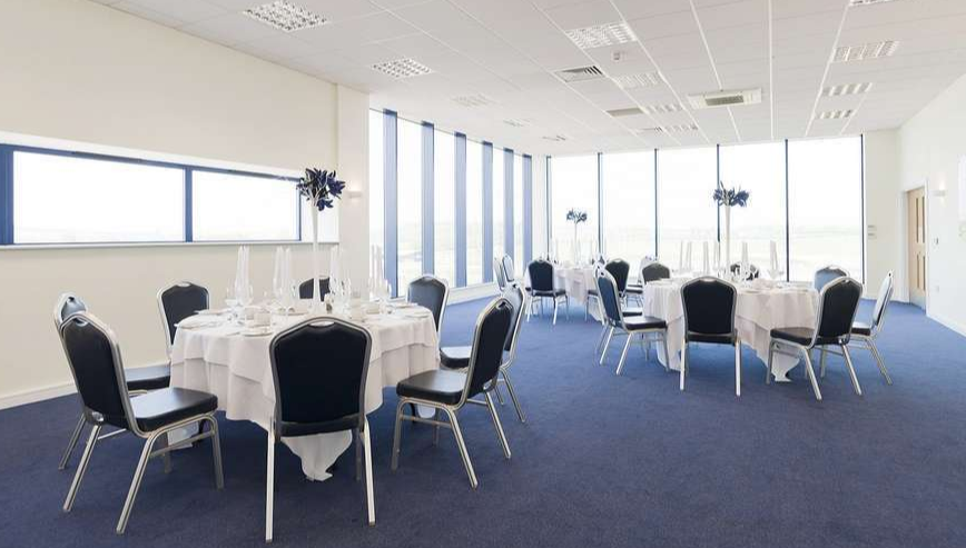 Hindlip Suite at Sixways Stadium, elegant event space with round tables and natural light.