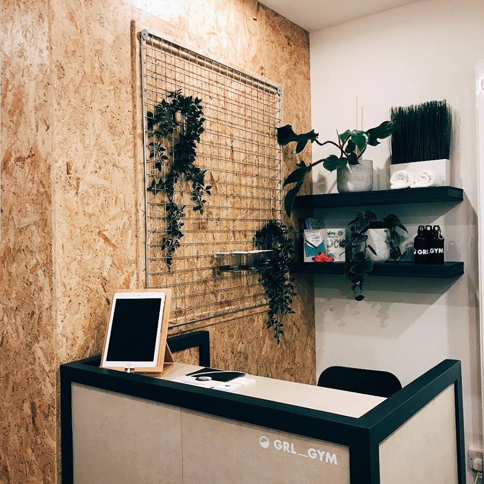 Stylish GRL GYM reception with plants, perfect for meetings and events.