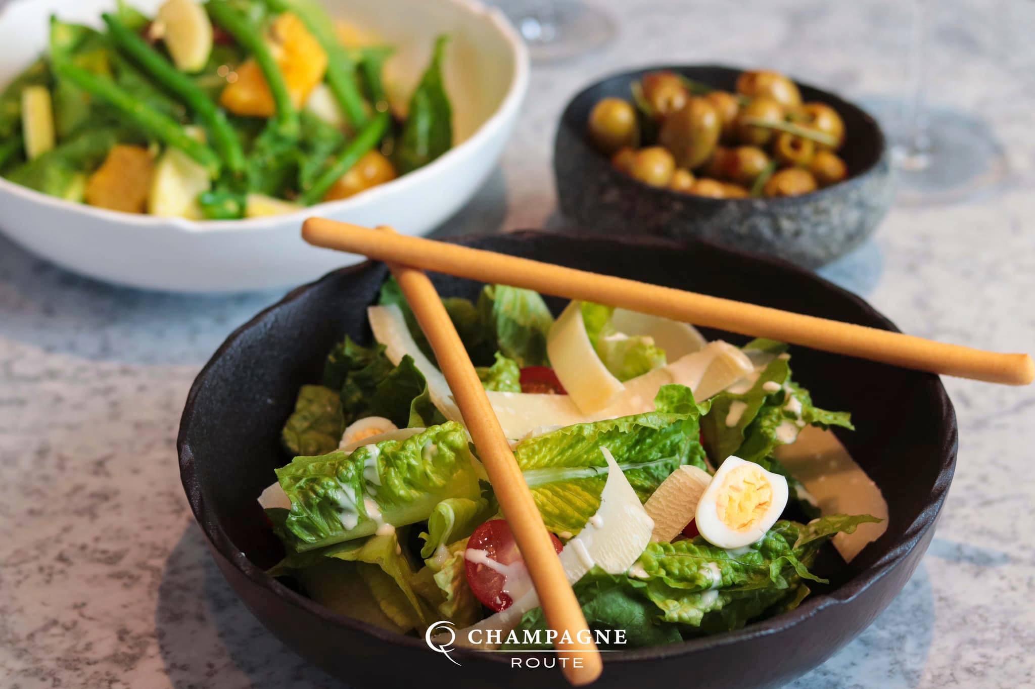 Elegant table setting with fresh salad and chopsticks for a Champagne Route event.