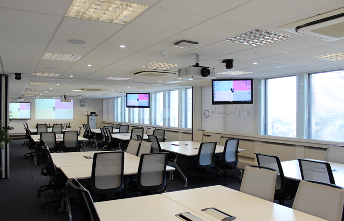 Modern collaborative meeting room with multiple screens, ideal for workshops and strategic meetings.