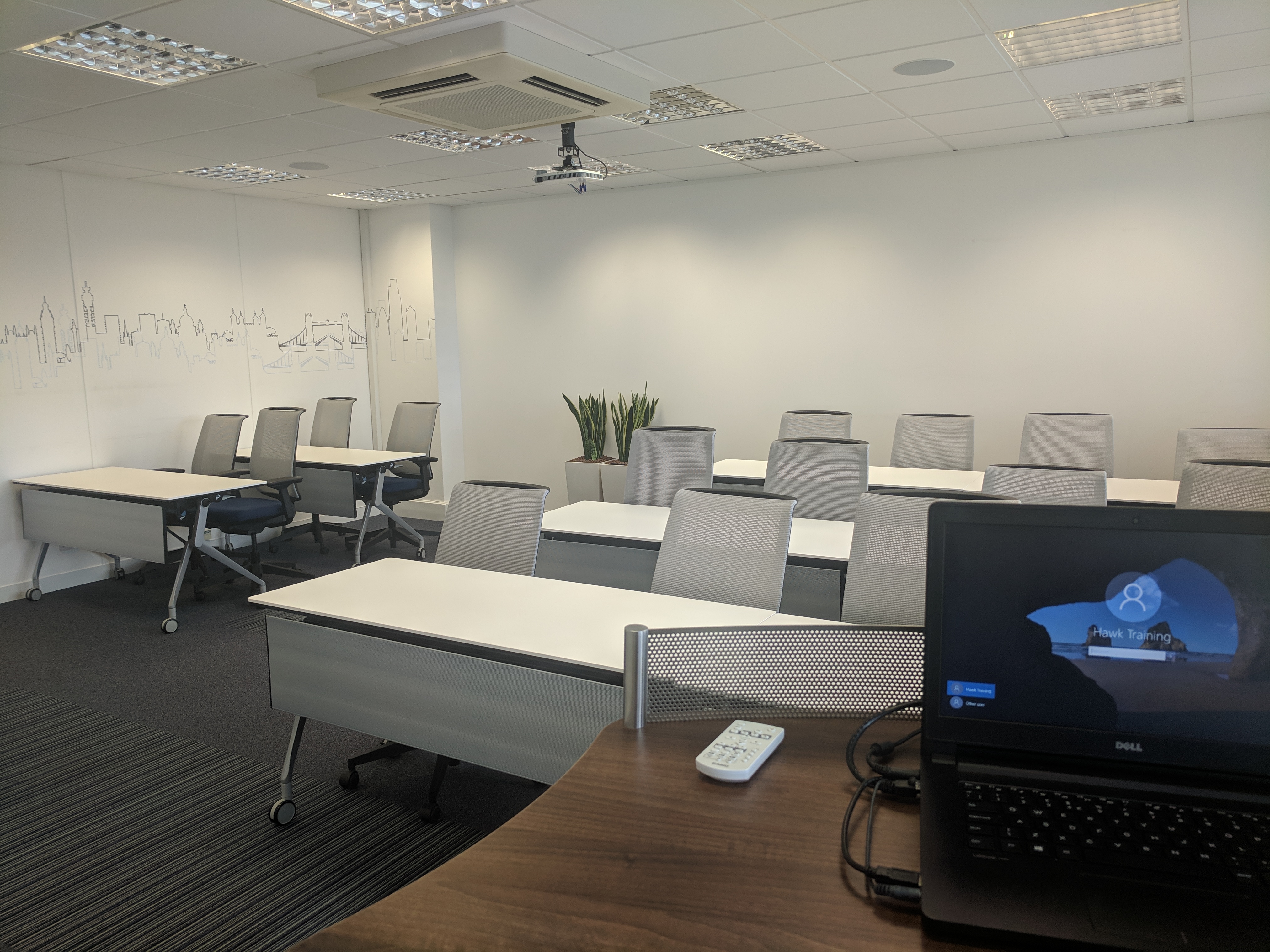 Modern meeting room in Hawk Training with projector for presentations and collaboration.