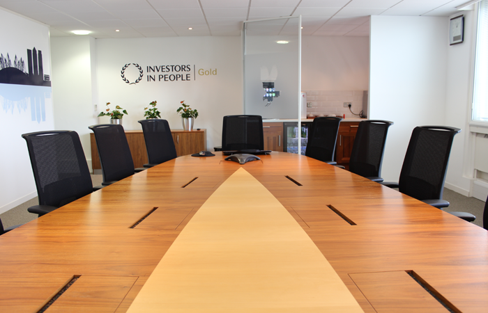 Modern conference room with large wooden table for effective meetings and presentations.