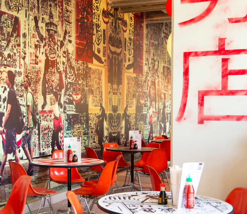 Vibrant dining space in Chop Shop with bold art, perfect for casual meetings and networking.