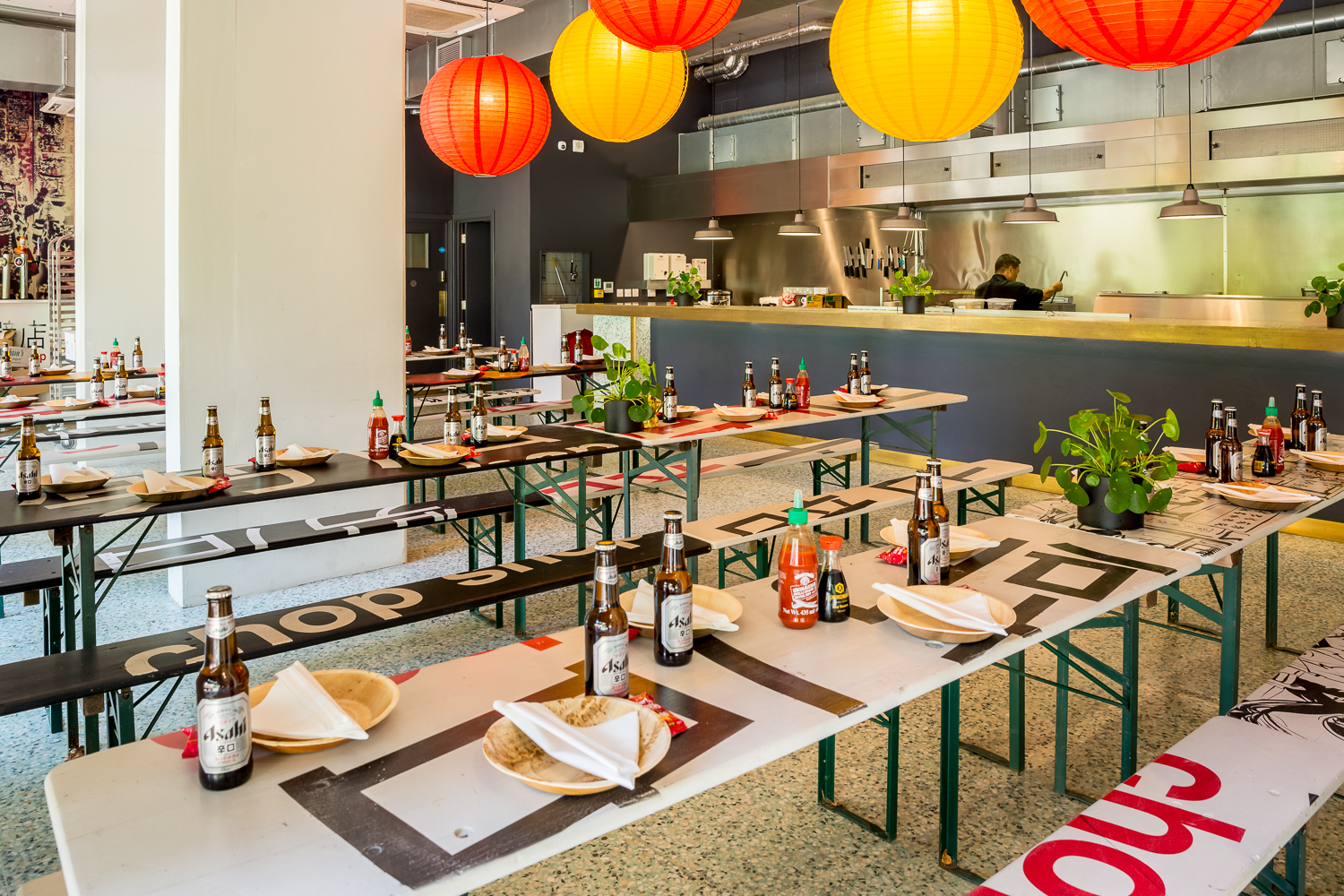 Vibrant event space with communal tables and colorful lanterns for casual dining.