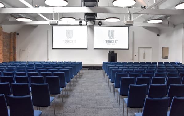 Main Hall theater-style setup with dual screens for corporate events and professional conferences.