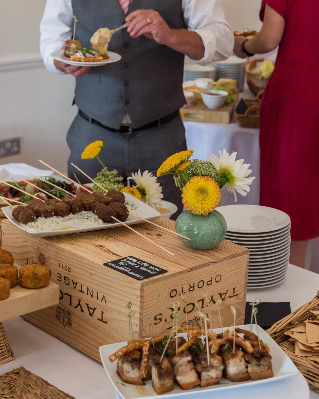 Elegant catering setup with skewered meatballs and floral arrangements at Linden House event.