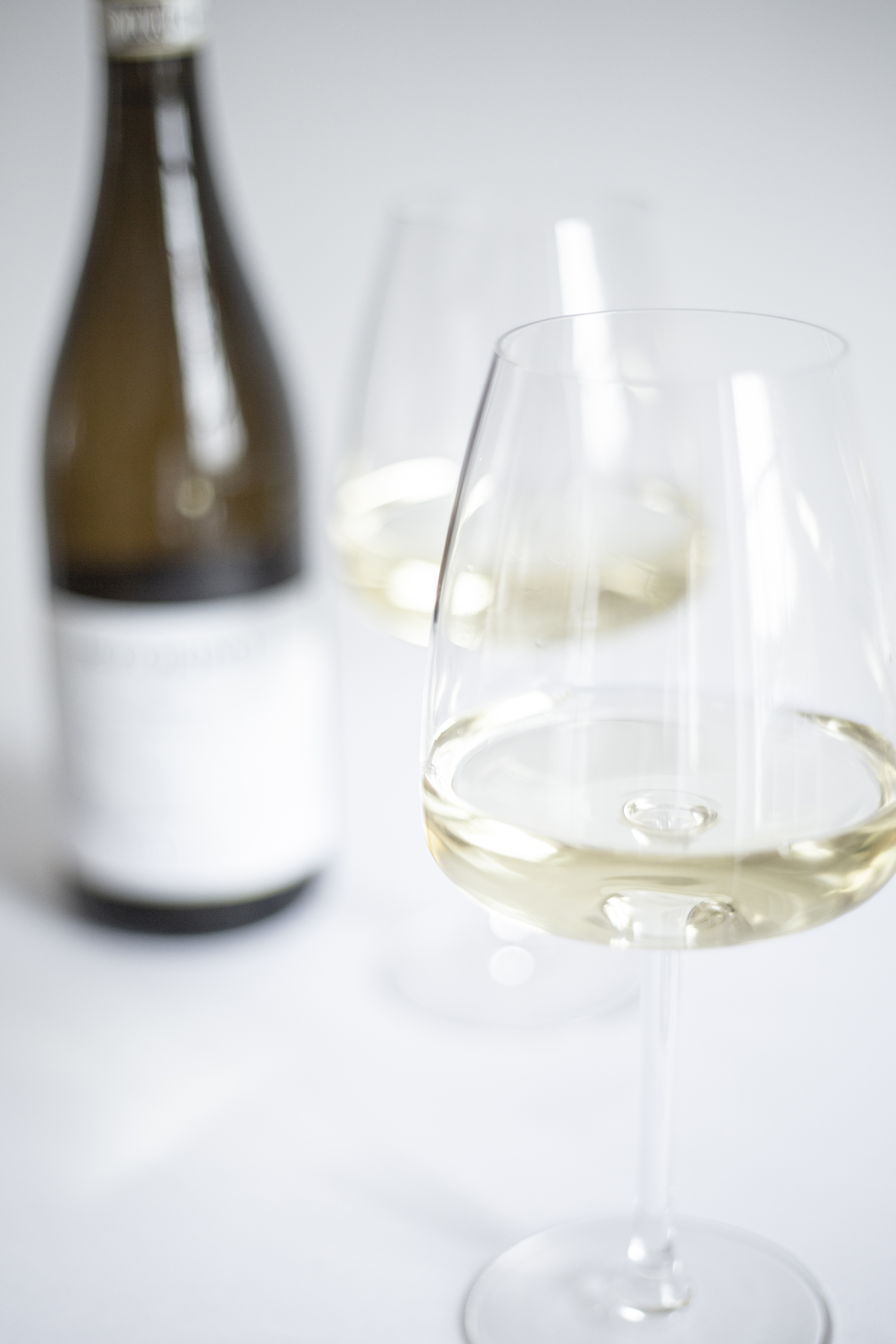 Elegant wine tasting setup in THE BOARDROOM, featuring crystal glasses and white wine.