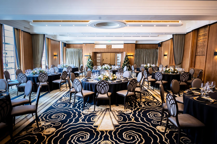 Elegant event space for Christmas parties with round tables and stylish decor.