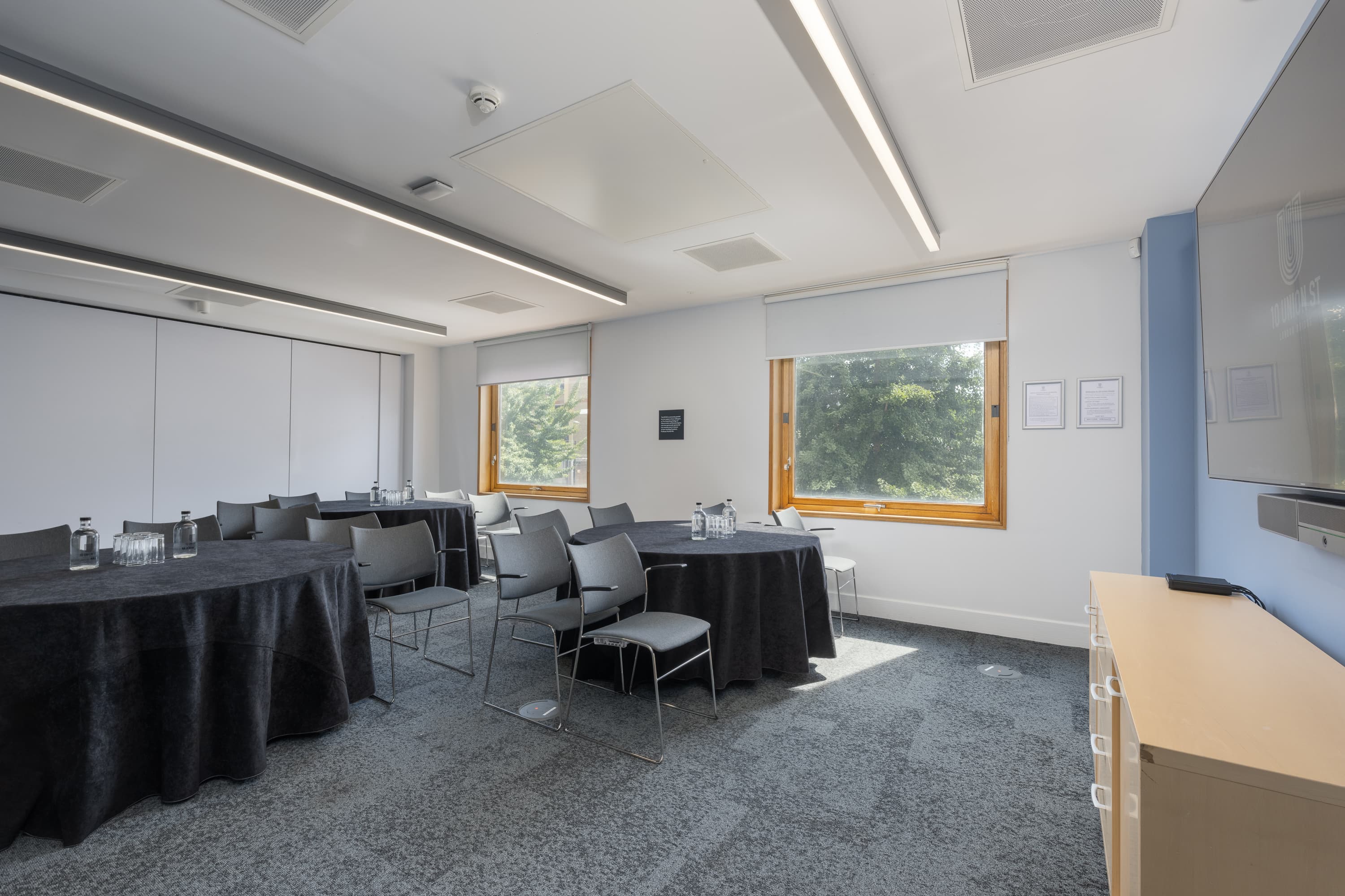 Modern breakout room with round tables for collaborative workshops and corporate event sessions.