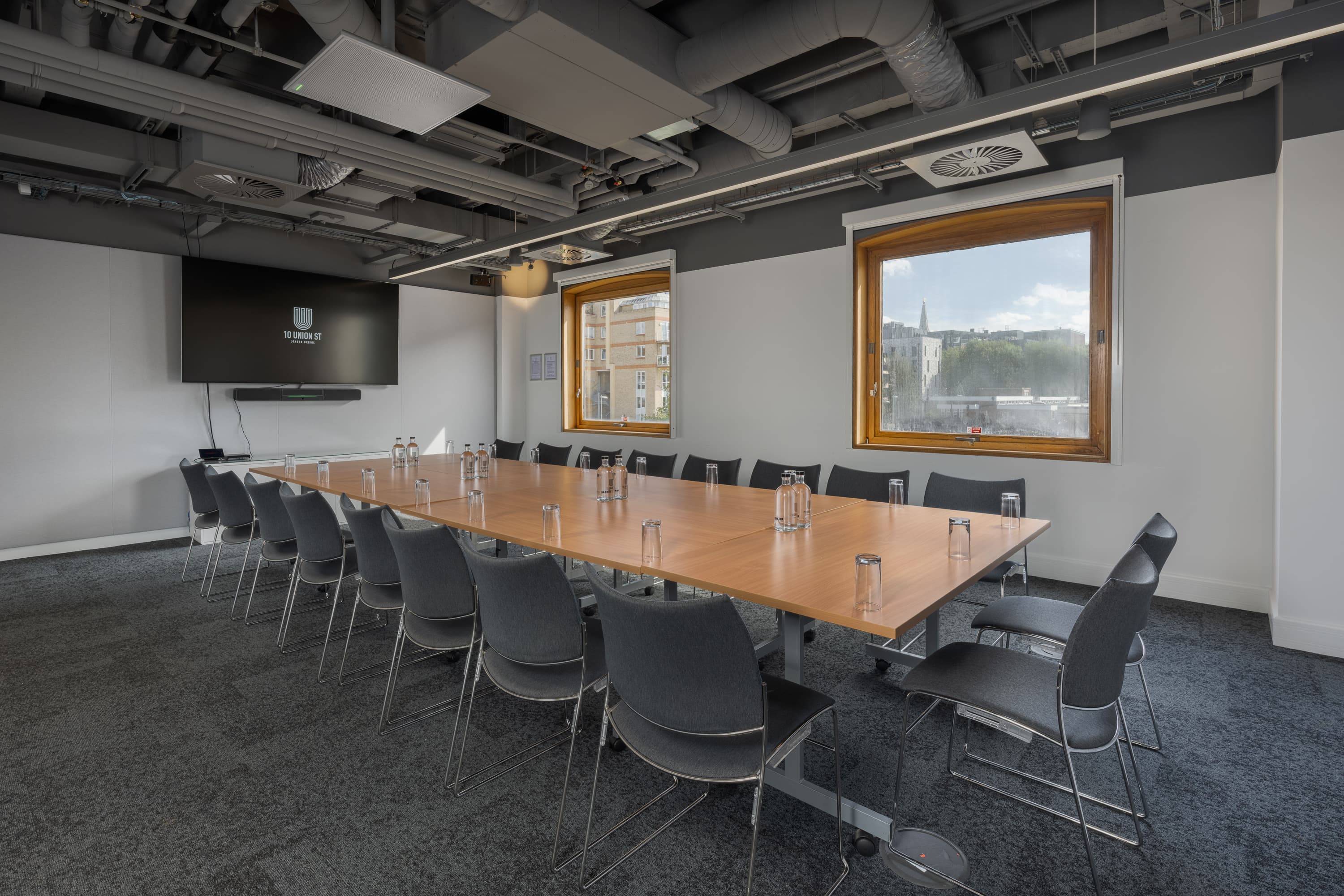 Industrial boardroom meeting space with natural light for corporate workshops.