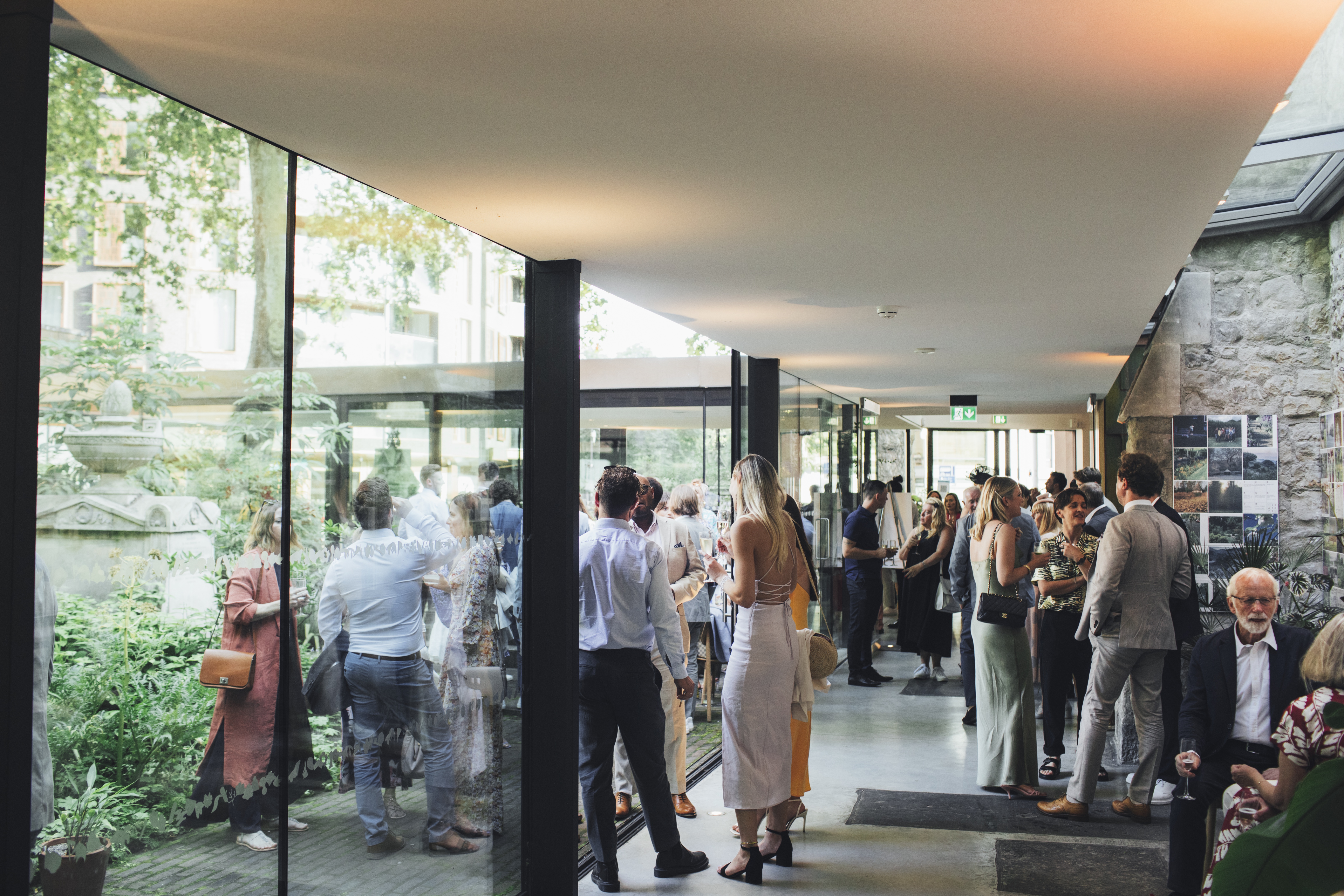 Vibrant networking event at The Garden Restaurant with glass walls and greenery.